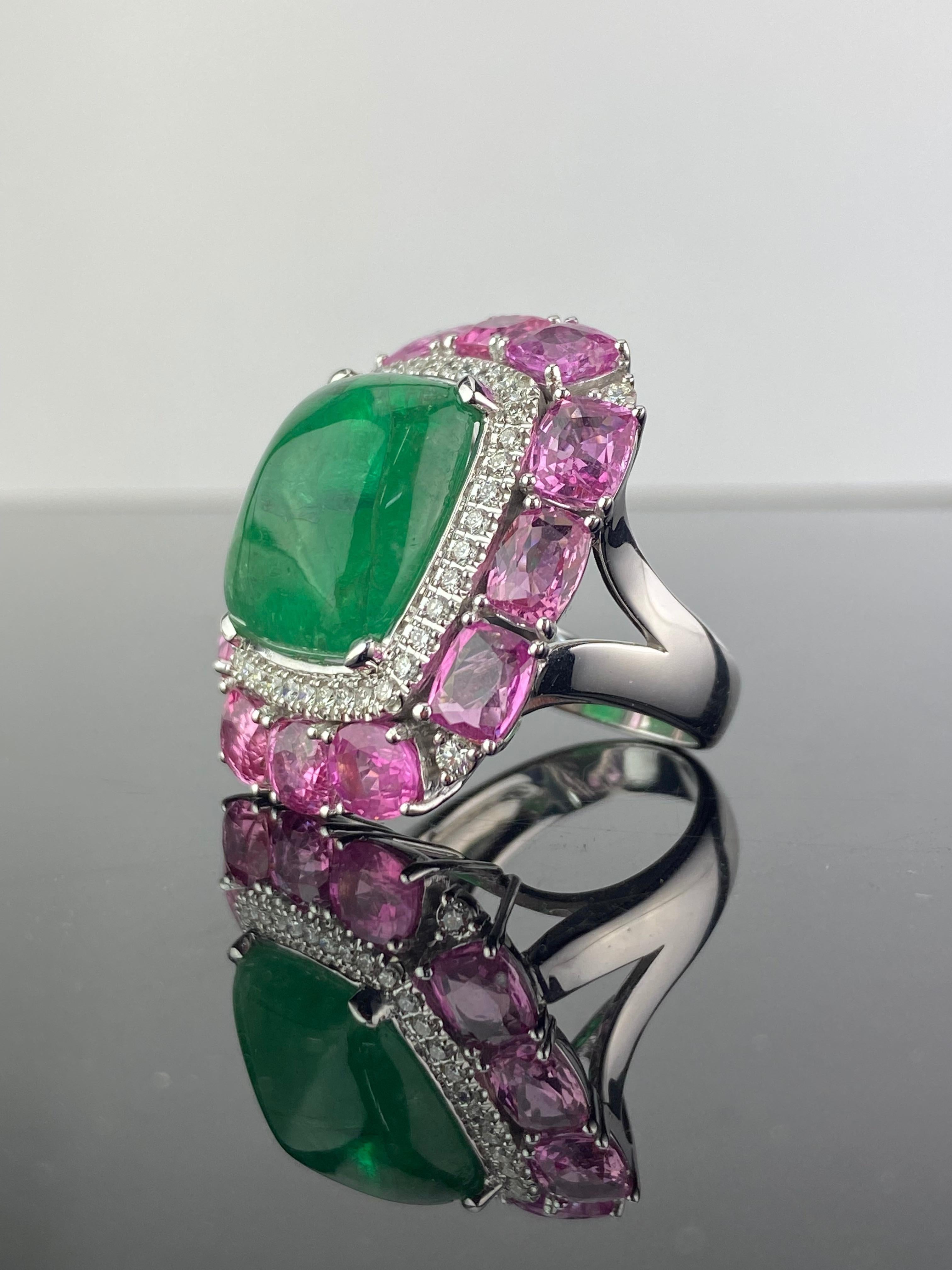 A beautiful 14.35 carat sugarloaf cabochon shaped Zambian Emerald and 9.02 carat Pink Sapphire, White Diamond cocktail ring. The Emerald has an ideal vivid green color, and the Pink Sapphire is completely transparent with great color and luster. The