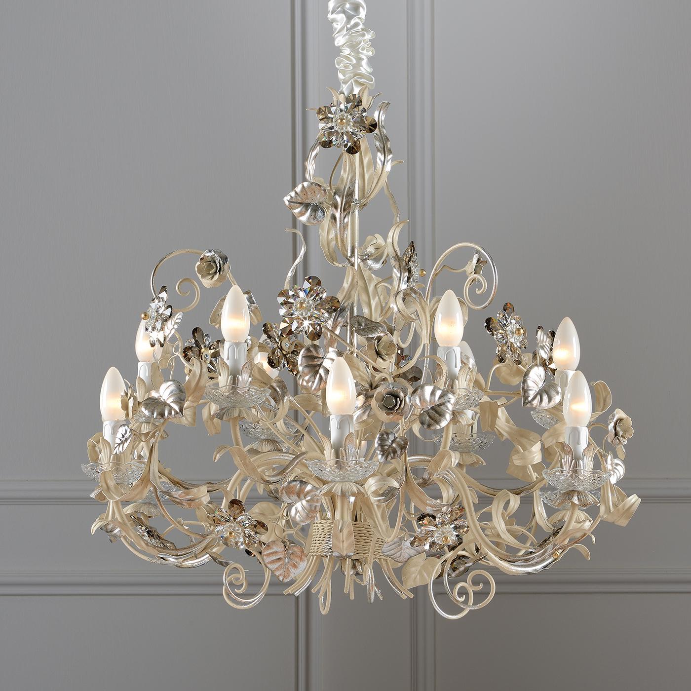 Blending traditional Italian style with natural influences, this chandelier sets the tone for sumptuous events. With a soft ivory coating accented with silver leaf, the chandelier features two tiers, each with six arms. The chandelier is completed