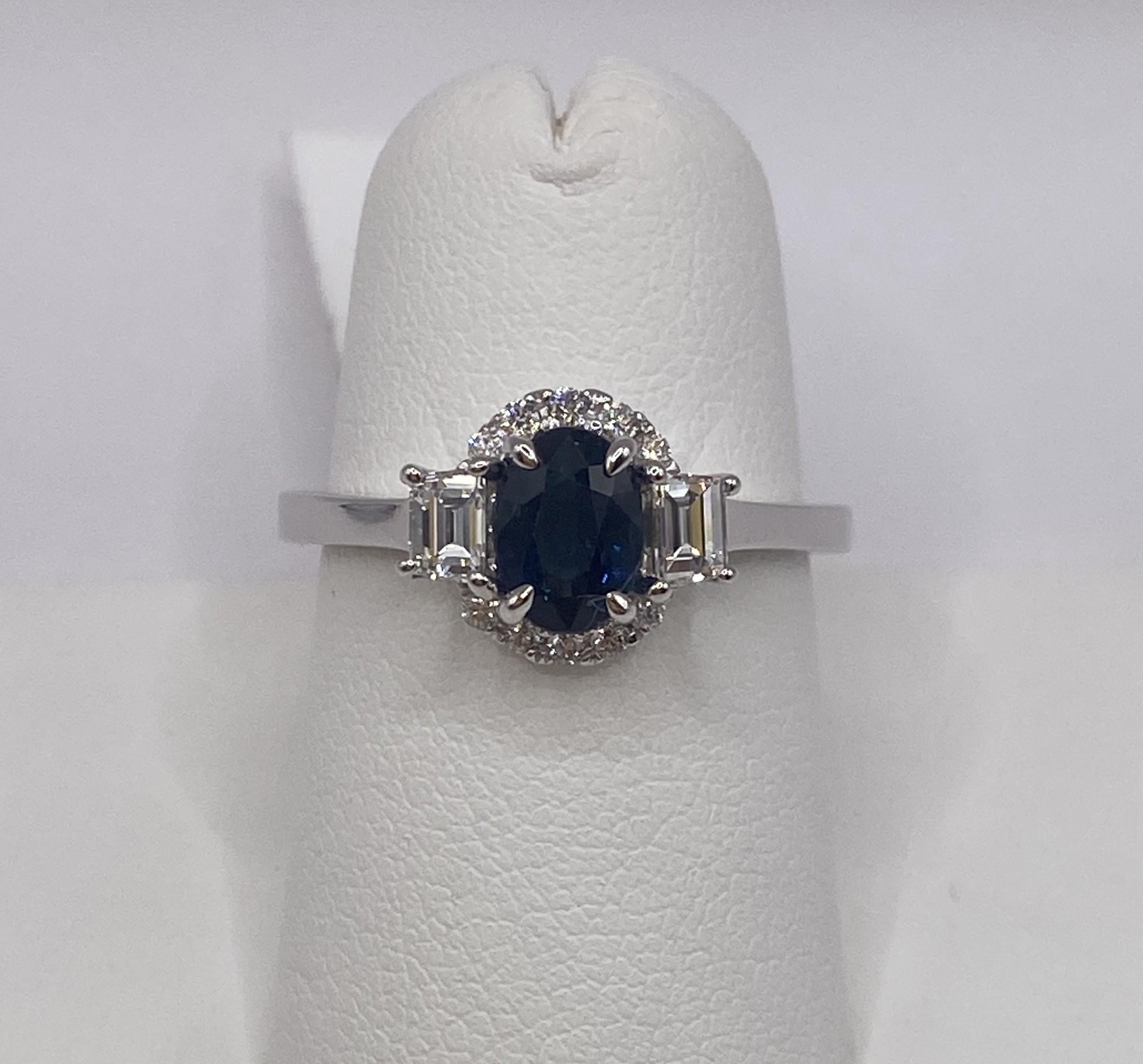 Metal: 18KT White Gold
Finger Size: 6.5
Total Carat Weight: 1.43ctw
(Ring is size 6.5, but is sizable upon request)

Number of Oval Cut Sapphires: 1
Carat Weight: 1.04ctw
Stone Size: 6.7 x 4.9mm

Number of Step Cut Trapezoid Diamonds: 2
Carat
