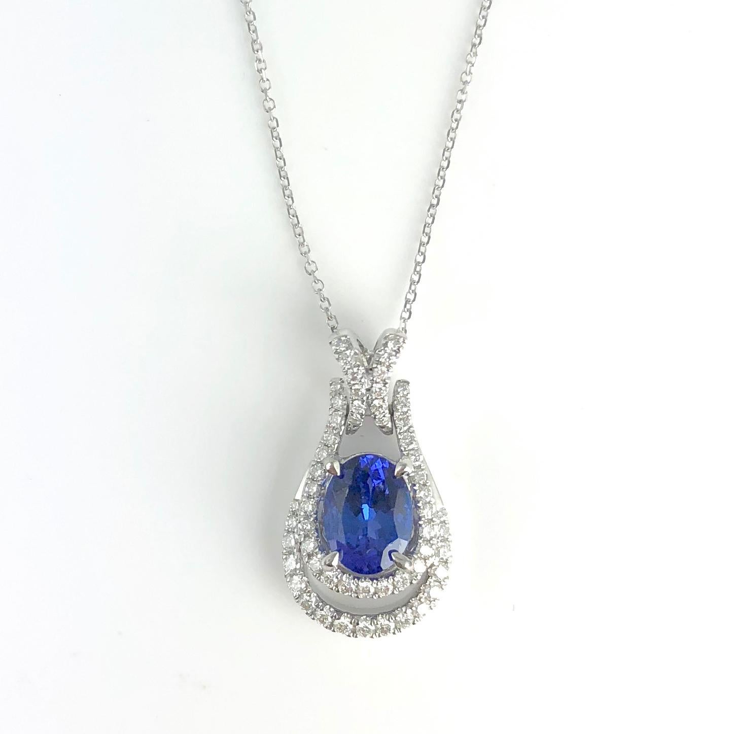 (DiamondTown) This sweet pendant features a 1.44 carat oval cut vivid blue tanzanite center, sitting in two loops of round white diamonds.

Tanzanite: 8mm x 6mm, 1.44 Carats
Diamonds: 56 round diamonds total 0.38 carats
Set in 18k White Gold

Many
