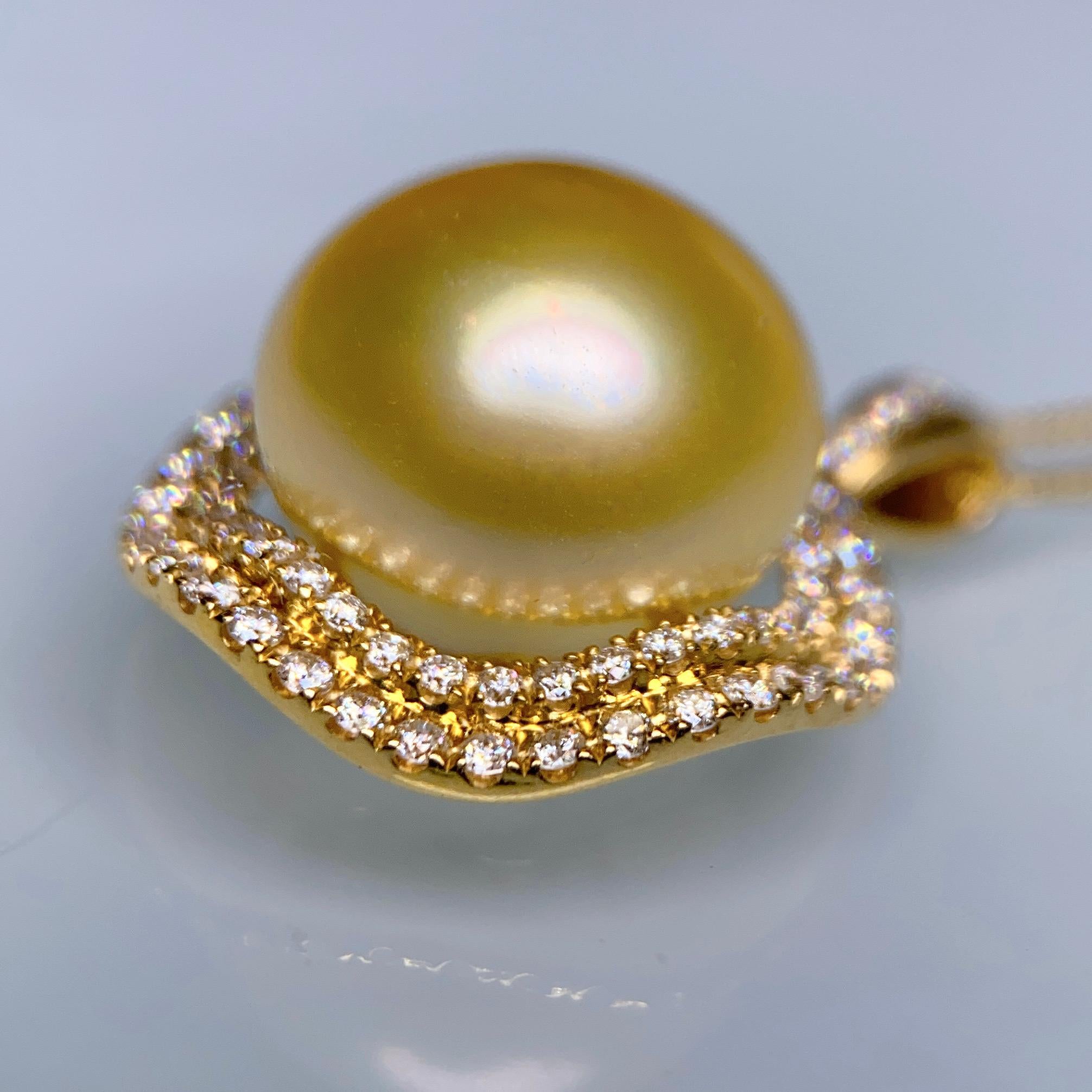 A 14.4 mm Light Golden Colour South Sea Pearl and Diamond Pendant in 18k Yellow Gold
It consists of a Button Shape South Sea Pearl with Very Good Lustre and Very Minor Surface Blemish
The Pearl is Light Gold in colour with Green Overtone 
Total