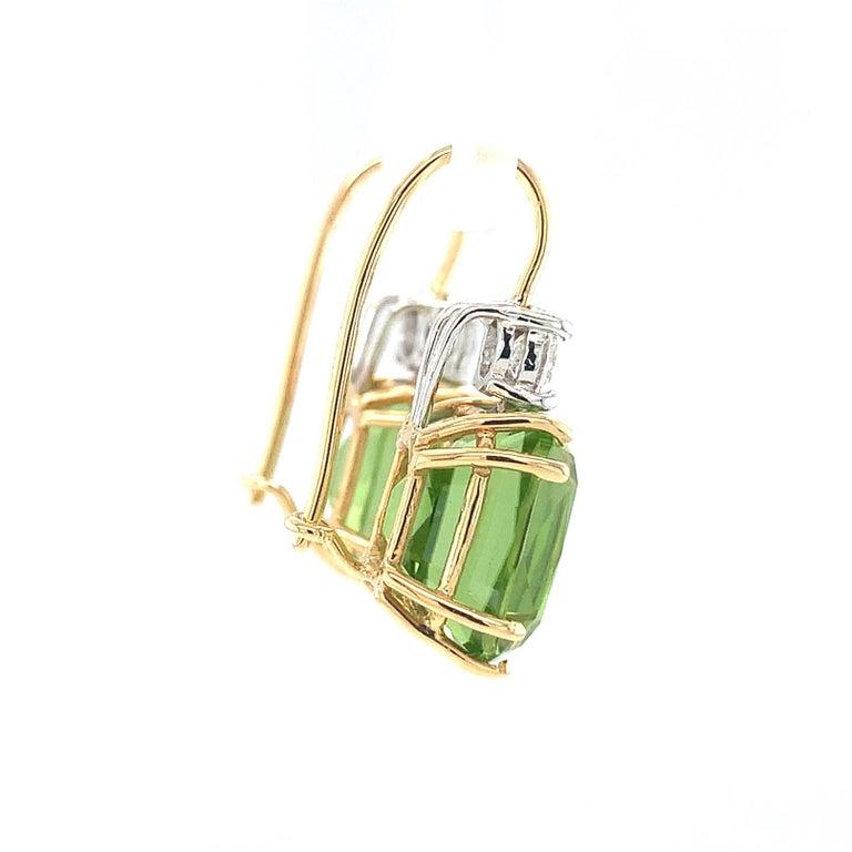 An unusually large matched pair of velvety, Granny Smith apple green color peridots are featured in these earrings. They are perfectly matched and extremely fine quality, which is rare in larger sizes of gems. Set atop the cushion cut peridots are