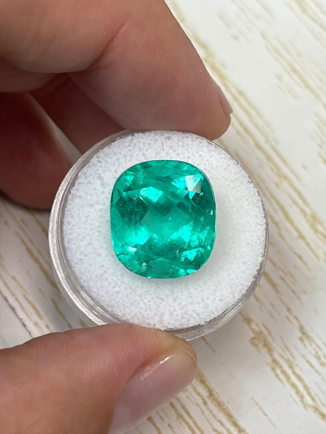 Stone: Emerald
Weight: 14.44-carats
Shape: Cushion Cut
Clarity: Transparent
Luster: Very Good
Color: Vivid Bluish Green
Measurements: 15.39mm x 13.68mm x 11.14mm
Geographic Origin: Colombia
Treatment: Natural, Minor Oiling

Comments: Due to their