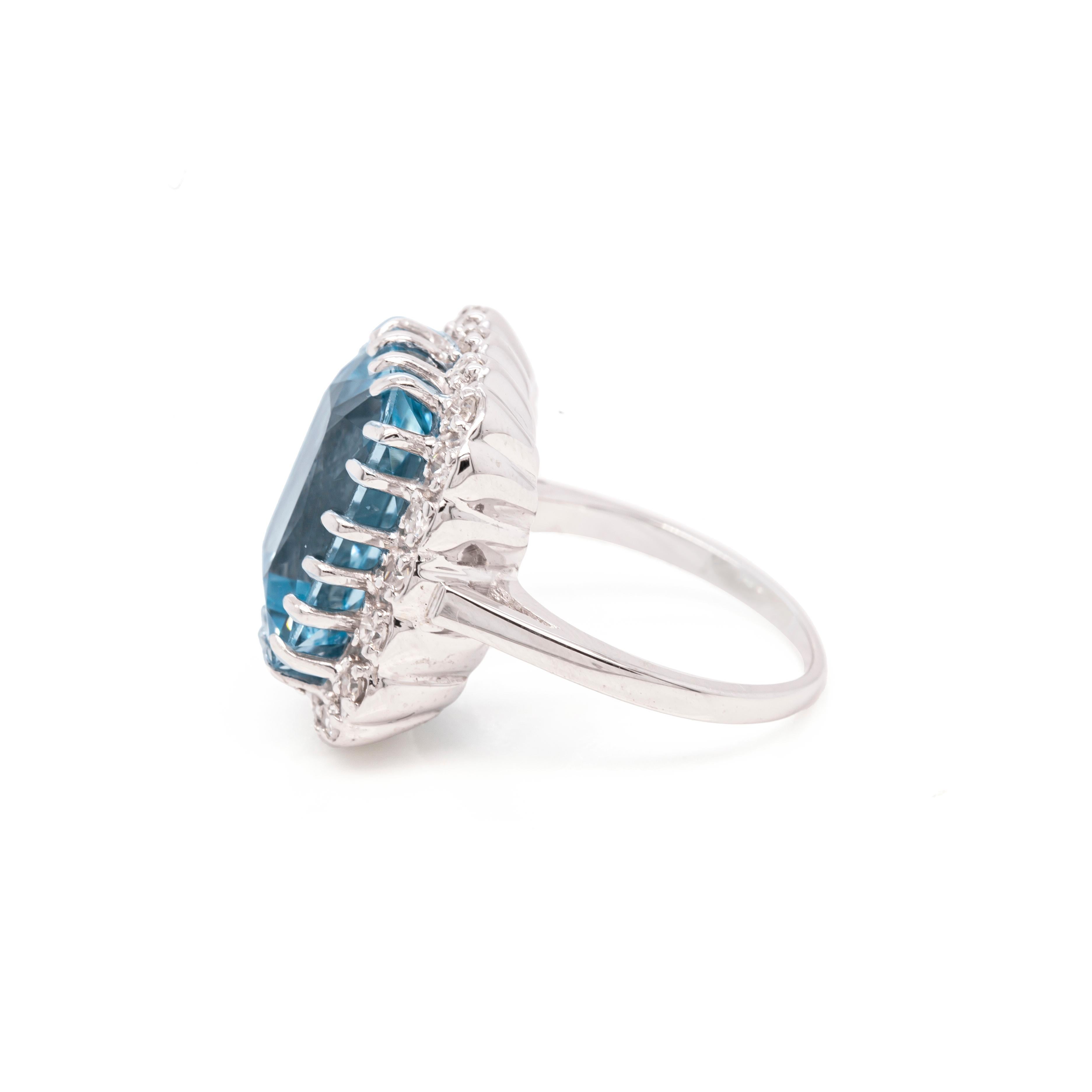 This spectacular 14 carat white gold cocktail ring features a rectangular crisscut aquamarine in a rich sea-blue colour, weighing an impressive 14.46 carats, mounted in a twenty claw, open back setting. The breathtaking gemstone is beautifully
