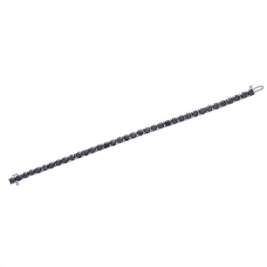 This is a white gold tennis bracelet set with black diamonds. This exquisite bracelet is crafted in 14K white gold and adorned with black diamonds. The black diamonds add elegance and allure, contrasting beautifully against the white gold setting.