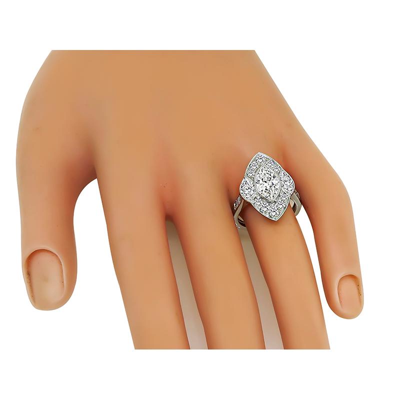 Este es un anillo de compromiso de platino increíble. El anillo está centrado con un brillante diamante de talla marquesa que pesa aproximadamente 1,44 ct. El color del diamante es J con claridad VS. El diamante central está acentuado por