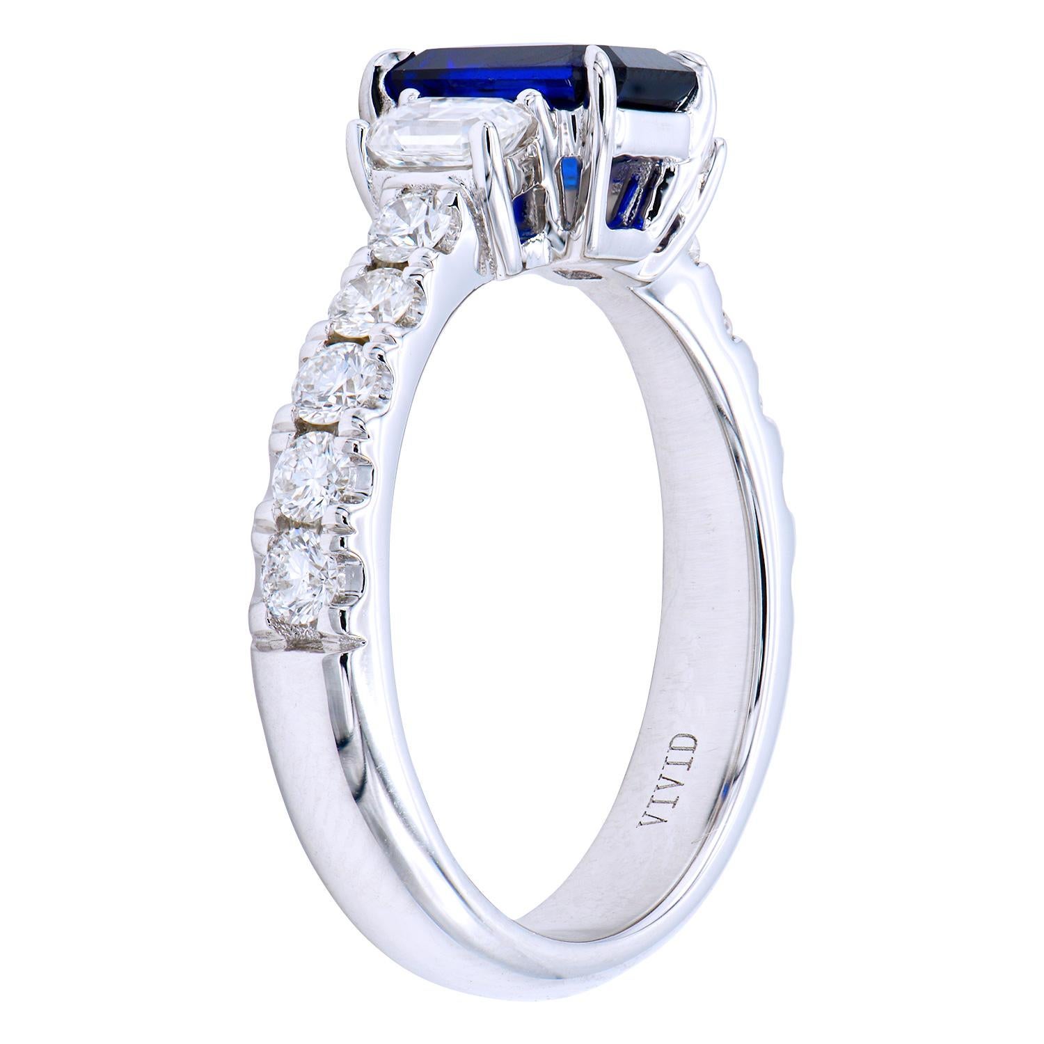 This stunning 1.45 carat Ceylon, Emerald cut, Blue Sapphire is set with 2 Emerald cut diamonds on either side totalling 0.44 carats and then with round diamonds set into the band totaling 0.48 carats. The diamonds are VS2, G color. The ring is made