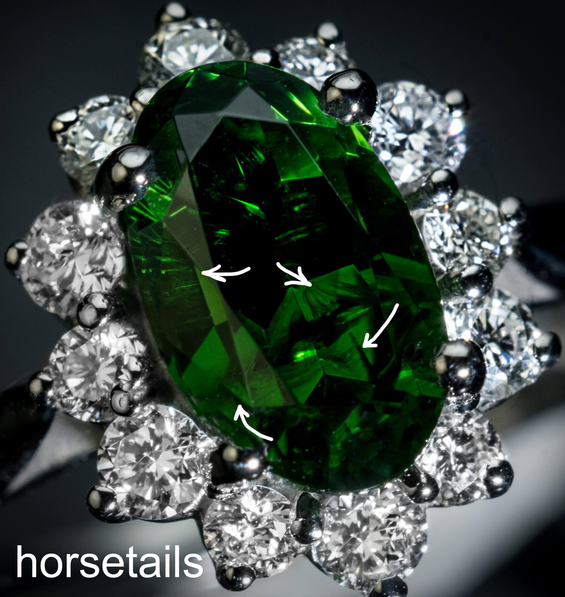 This contemporary custom-made platinum cluster ring features an oval 1.45 ct Russian demantoid (8 x 4.88 x 4.1 mm) from the Ural Mountains of dark green color. The demantoid is surrounded by bright white diamonds ( 0.33 ct total weight, F-G color,
