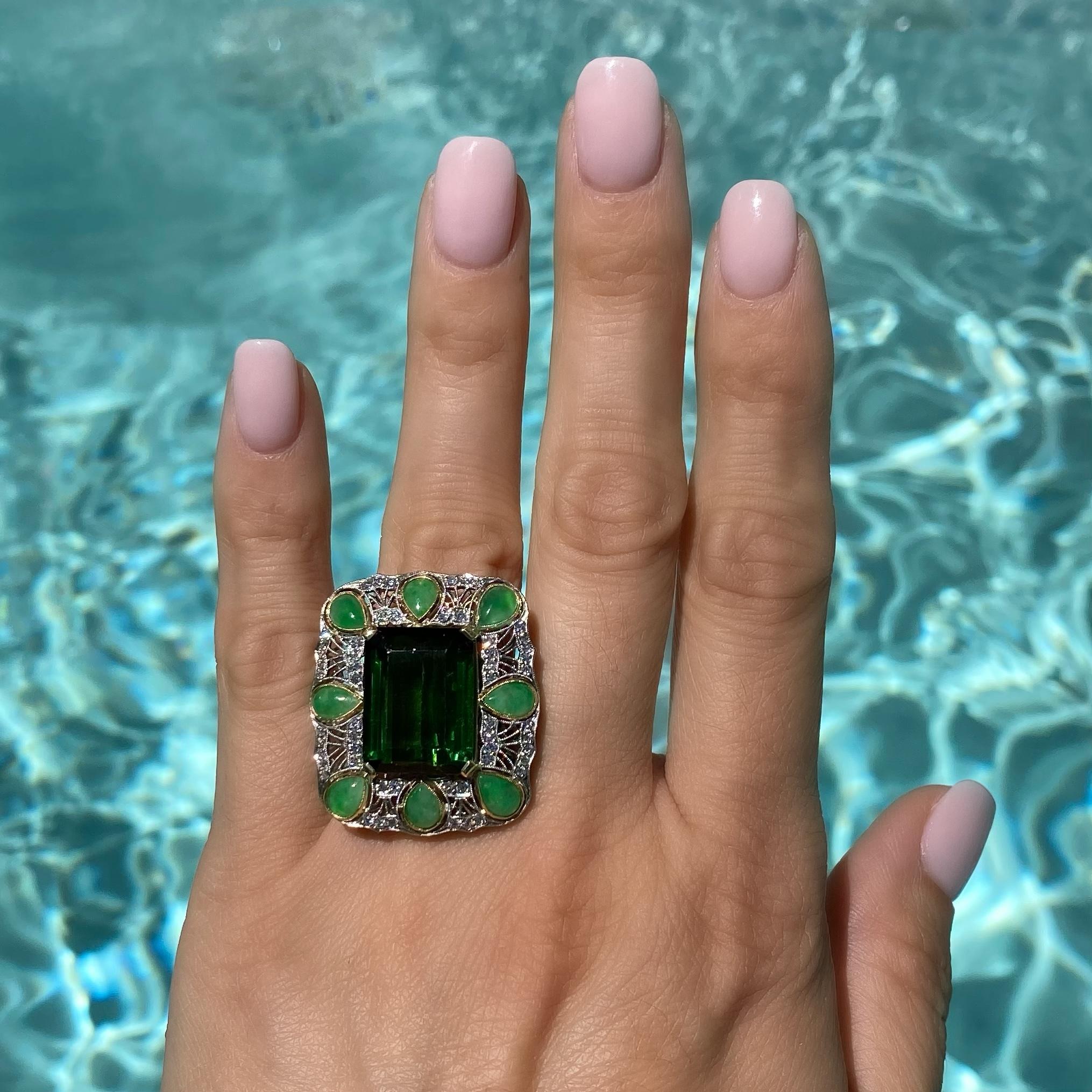 Simply Beautiful and finely detailed Cocktail Ring, center securely set with a 14.50 Carat Green Tourmaline surrounded by Diamonds, approx. 0.84tcw and enhanced with 8 pear shape Jadeite stones set in 18K Yellow Gold Bezel settings. Hand crafted