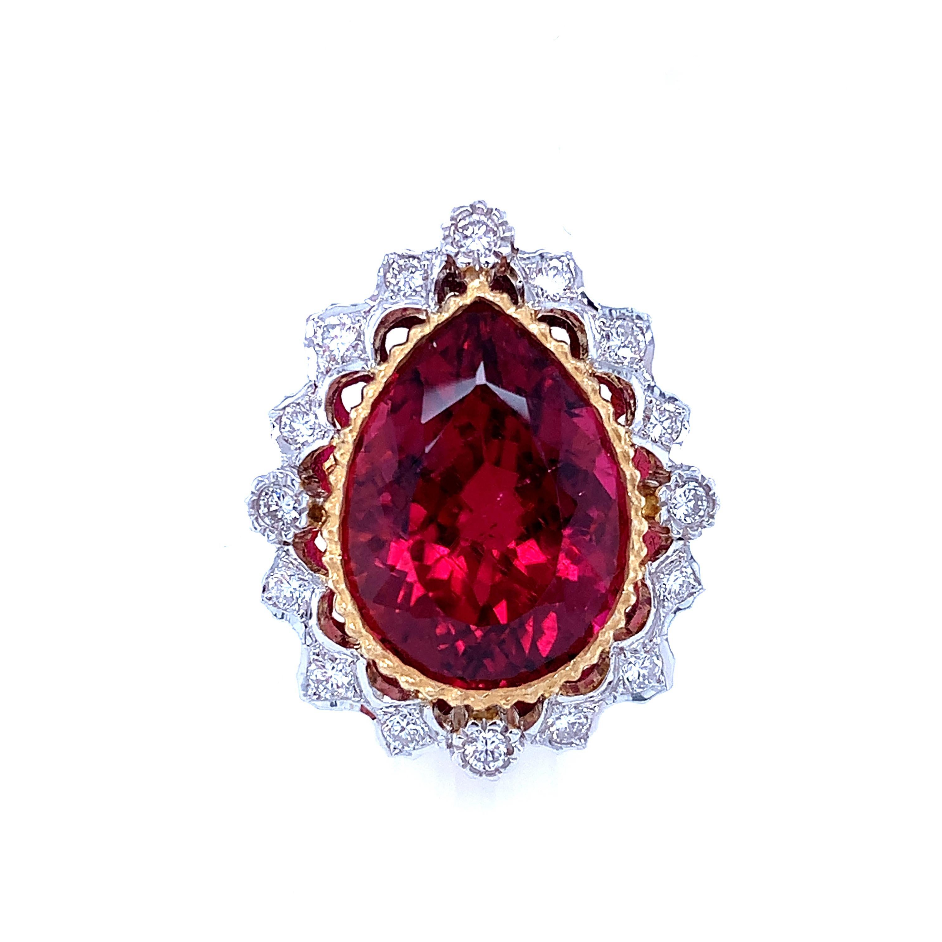 A gorgeous 14.58 carat pear-shaped rubellite tourmaline is featured in this stunning handmade 18k white and yellow gold cocktail ring. The tourmaline has excellent clarity and vivid fuchsia red color that is complemented beautifully by the intricate
