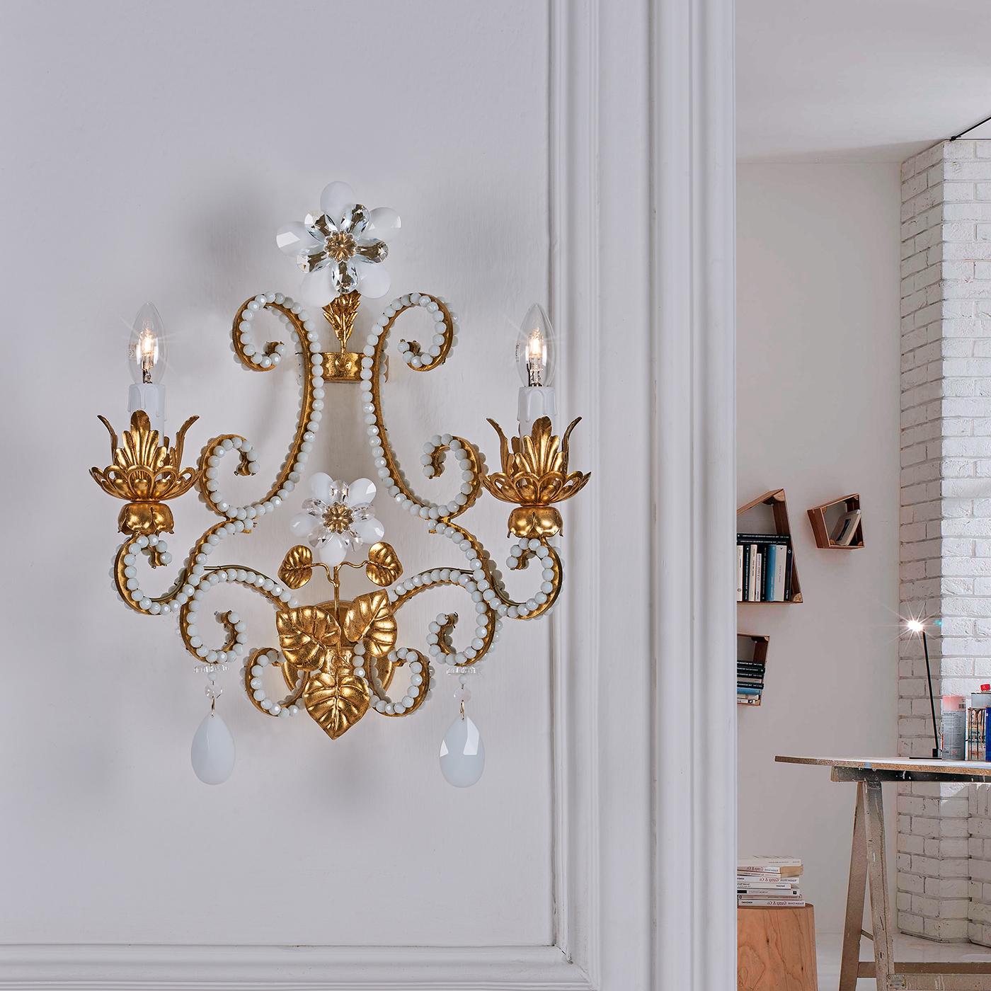 This is a delicate and classy wall lamp characterized by its rich variety of deluxe decorations. It consists of a metal structure decorated with gold leaf coating, rows of white ground beads and white crystal pendants to top it off. It is a