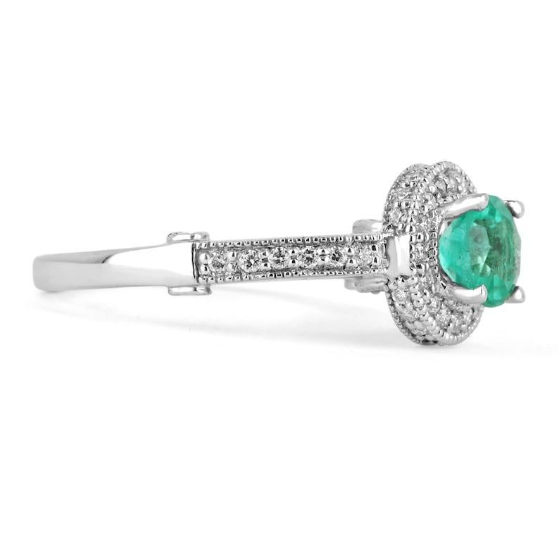 Color and brilliance can best describe this rare round Colombian emerald and diamond engagement ring 14K. The luminous, round, deep green Colombian emerald has amazing qualities that make it exclusive. The emerald is set in a secure four-prong