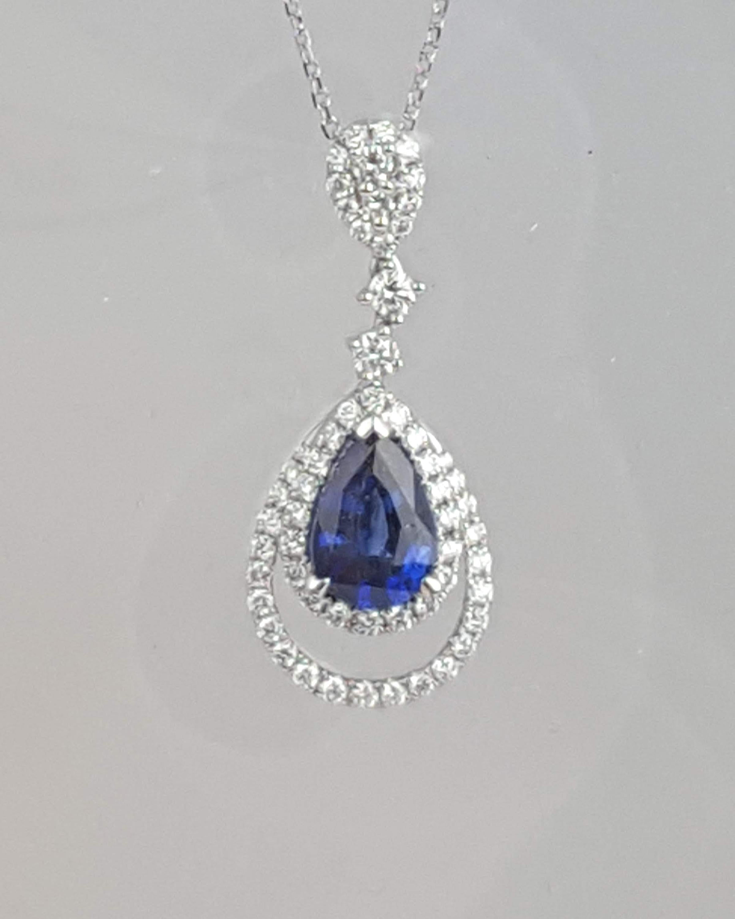 (DiamondTown) This sweet pendant features a 1.46 carat pear shape sapphire center, sitting inside an embellished double teardrop halo of round white diamonds. The body of the pendant dangles from two round white diamonds and a decorated