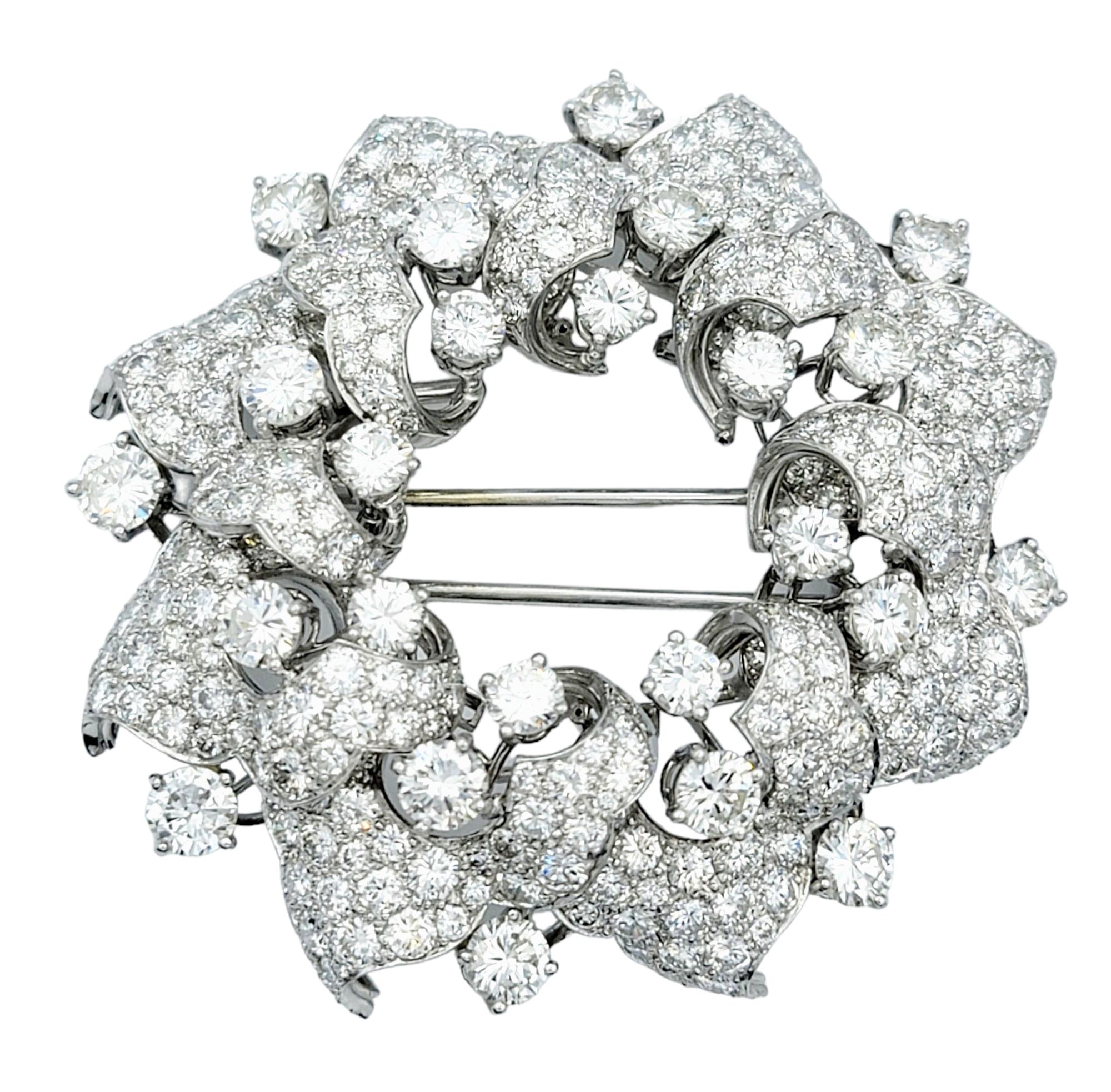 Cette magnifique broche en forme de couronne, sertie dans un luxueux platine, est une pièce époustouflante et opulente qui respire l'élégance intemporelle. Toute la surface de la couronne est recouverte de diamants de différentes tailles, créant