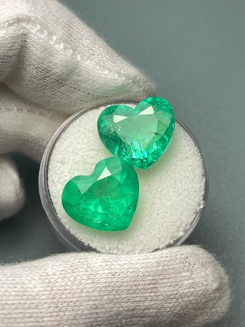 Stone: Emerald
Total Weight: 14.61-tcw
Shape: Heart Cut
Clarity: Transparent to Semi-Transparent
Luster: Very Good
Color: Yellowish Green
Measurements: 12.09mm x 13.52mm x 7.47mm // 12.09mm x 13.51mm x 9.01mm
Geographic Origin: Colombia
Treatment: