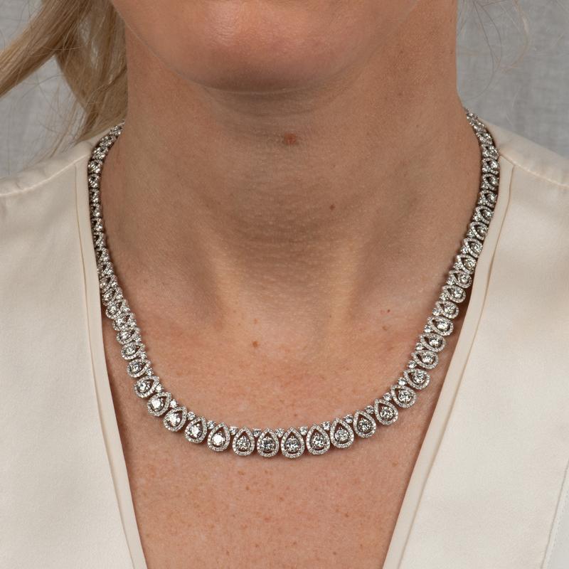 This beautiful and intricate necklace features 14.62 carat total weight in round diamonds surrounded by graduated pear shaped halos. Box & safety clasp. 
Measurements: Length approximately 16