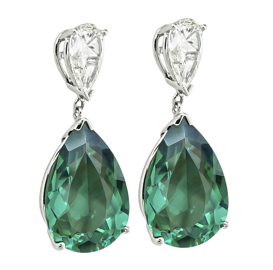 This is a stunning pair of 14k white gold earrings. The earrings feature lovely pear shape green tourmaline and diamonds that weigh approximately 13.48ct and 1.65ct respectively. The color of the diamonds is J-K with VS2-SI1 clarity. The earrings