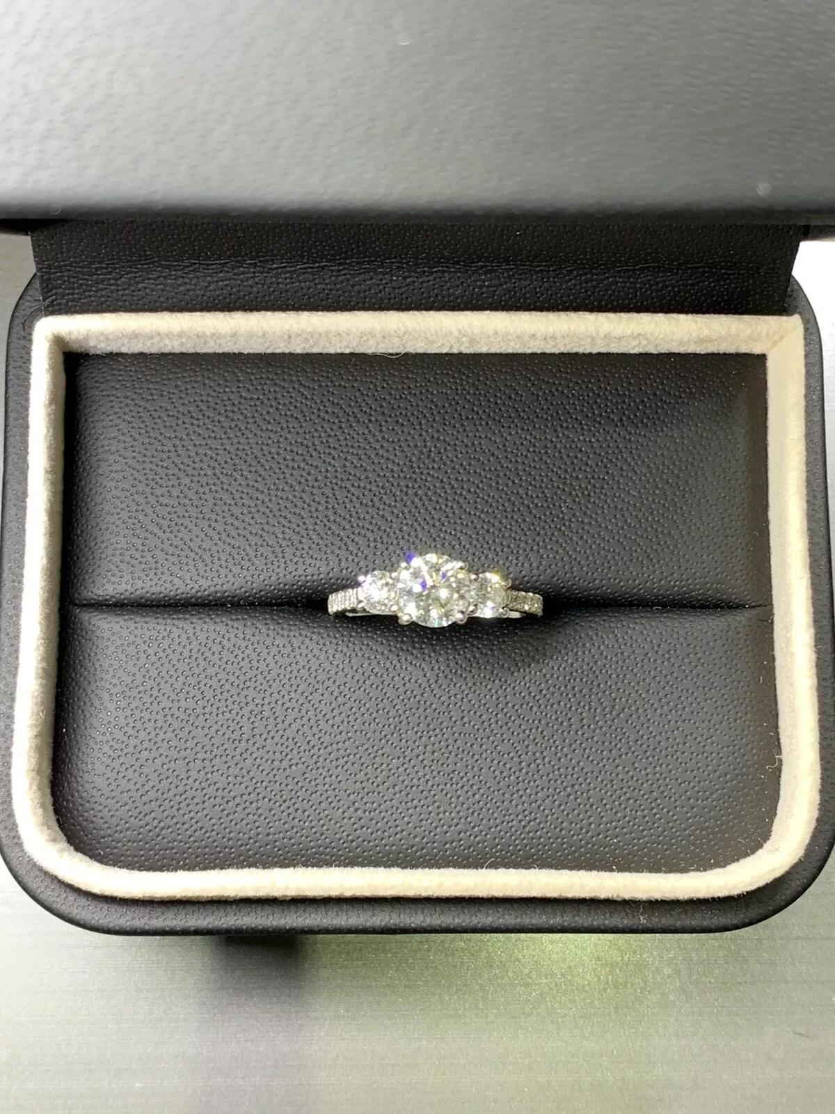 This stunning platinum engagement ring from Trilogy features a trio of beautiful round diamonds with a total carat weight of 1.46ct. The diamonds are set in a classic three-stone style, with a band width of 2-2.5mm. Beautiful classic trilogy