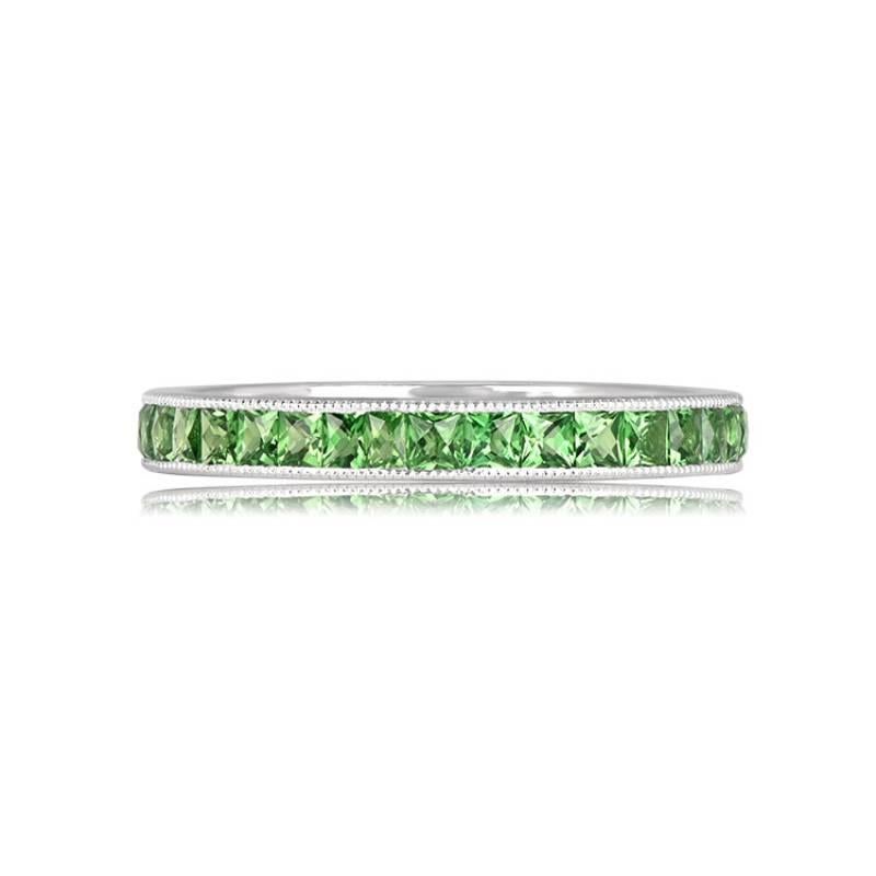 This exquisite eternity band, crafted in platinum, showcases 1.46 carats of stunning French-cut tsavorite garnets. The band, with a width of 2.60mm, is meticulously designed with a channel-set arrangement and adorned with delicate milgrain