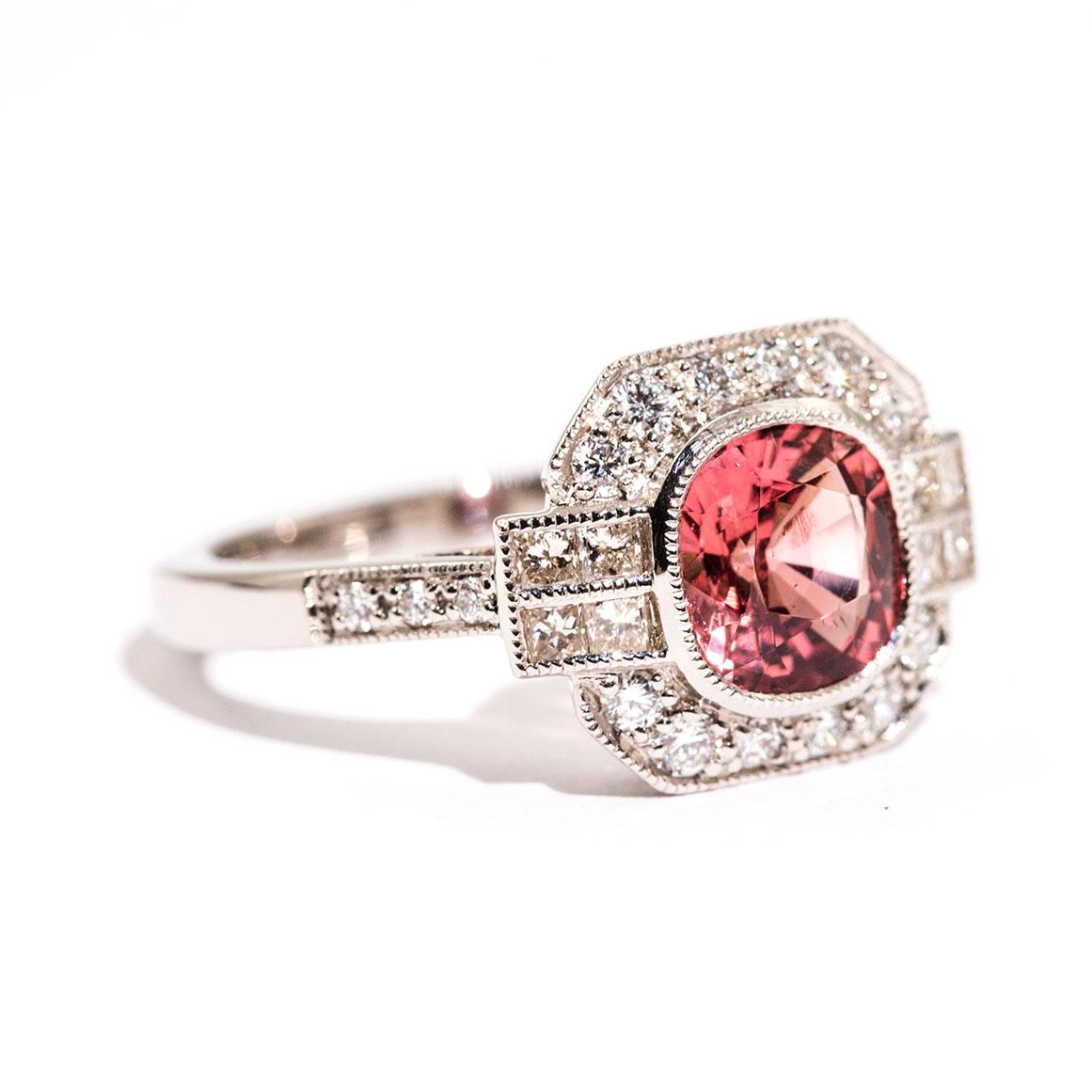 Forged in platinum is this alluring Art Deco inspired ring that features a captivating 1.47 carat bright reddish orange cushion cut spinel complimented by a total of 0.52 carats of sparkling round brilliant cut diamonds. We have named this stunning