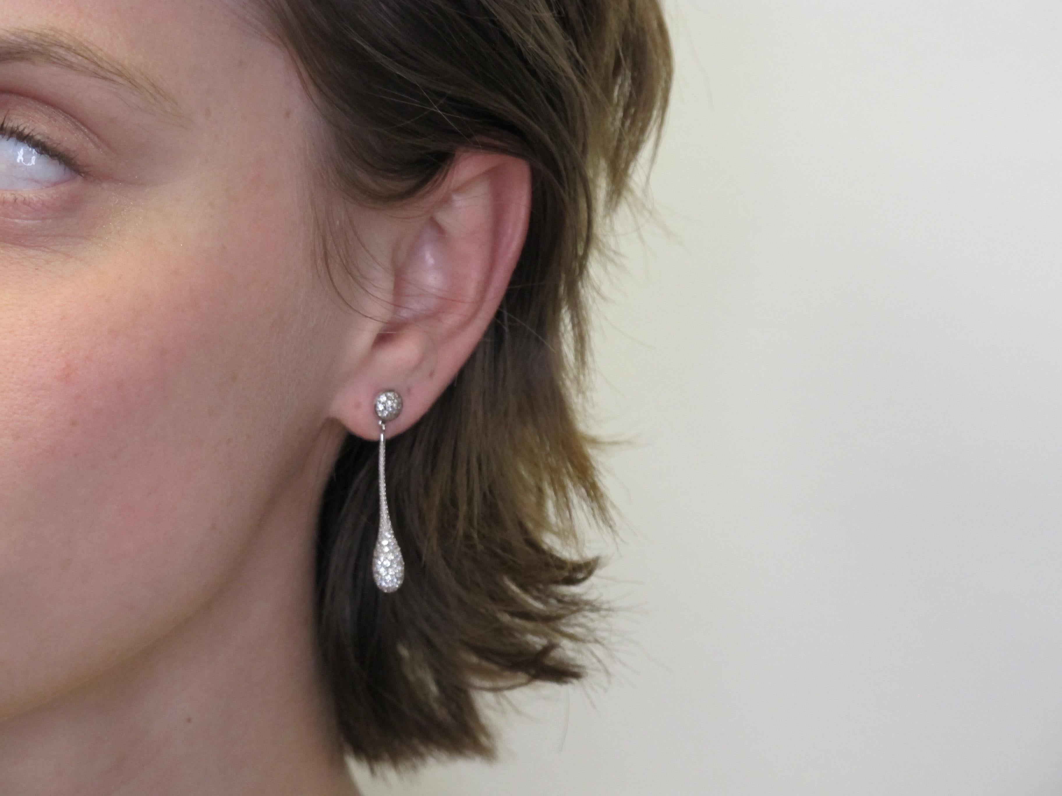 The design of these earrings is truly remarkable. These elongated teardrops feature sparkling diamonds pave set 360 degrees around the dangling portion of the earrings so they are exquisite when viewed from any angle. These 18k white gold earrings