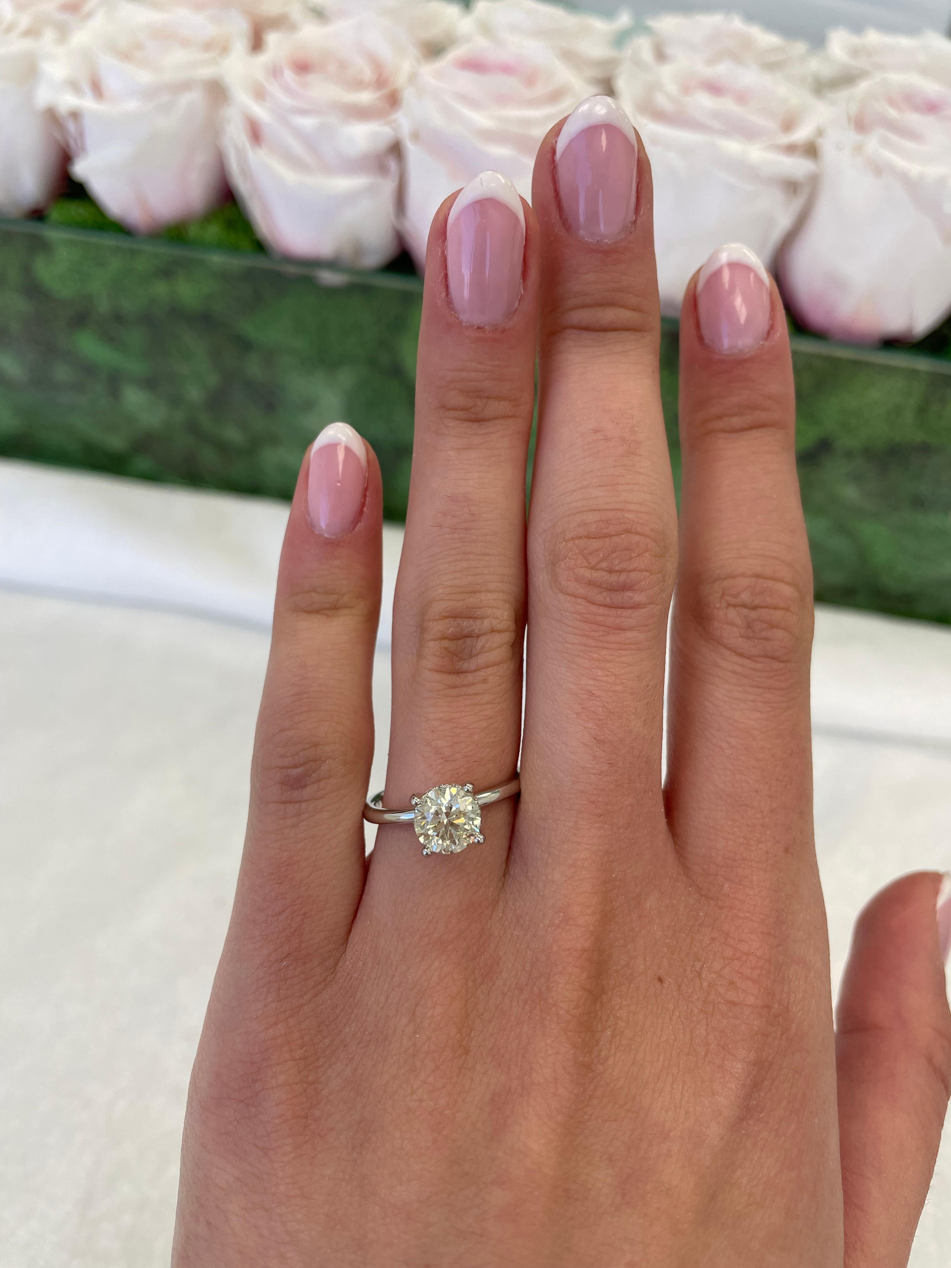 Classic solitaire diamond engagement ring with hidden halo.
1.60 carats total diamond weight.
1.47 carat round brilliant diamond, approximately J/K color grade and I1 clarity grade. Complimented by 0.13 carats of round brilliant diamonds,