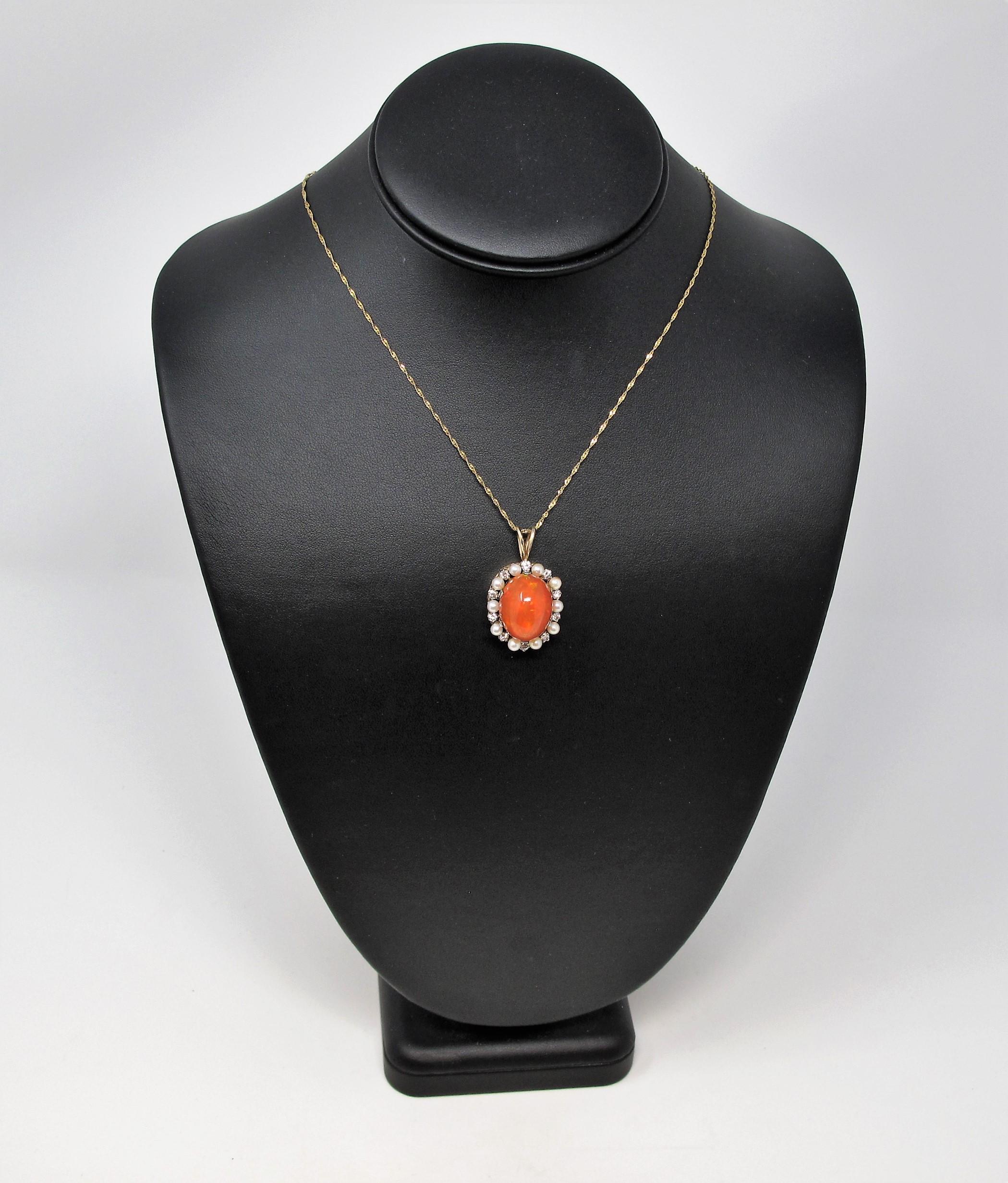 This stunningly bold fire opal pendant with diamond and pearl accents is bursting with brilliant color. Featuring a high polished orangey-red fire opal stone, this gleaming pendant shimmers beautifully in the light, displaying its wide play of