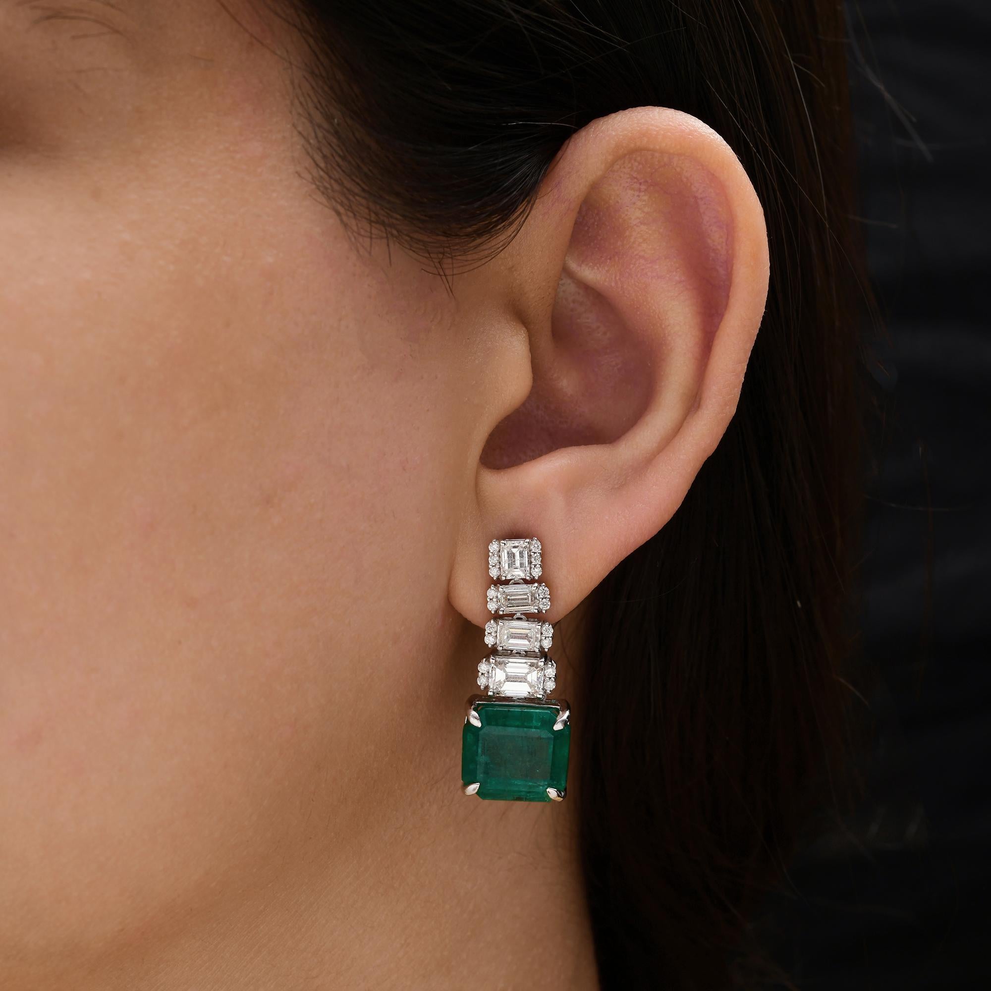 Orecchini pendenti con smeraldo dello Zambia da 14,73 carati e diamanti da 3,45 carati in oro bianco 18 carati 
Gli orecchini presentano un moderno design a goccia verticale con una cascata di diamanti taglio smeraldo, ciascuno delicatamente