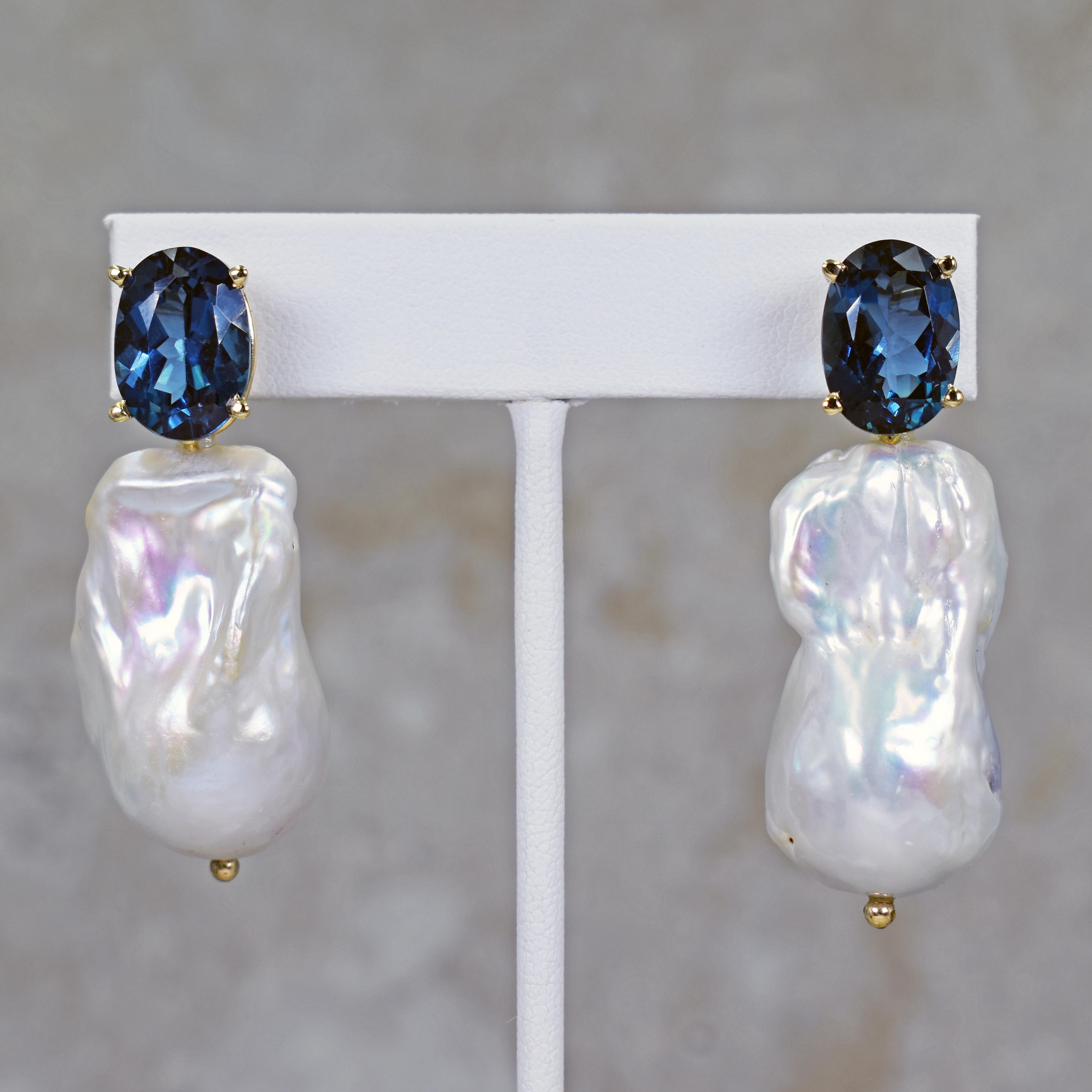 Gorgeous and unique 14k yellow gold stud earrings featuring two oval-cut London Blue Topaz gemstones, totaling 14.74 carats, with large Freshwater Baroque Pearls. Stud earrings are 2 inches or 51 mm in length. These artisan statement drop earrings