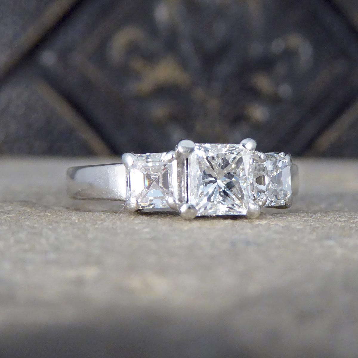Unser bezaubernder Drei-Stein-Ring mit Princess- und Asscher-Schliff aus Platin ist ein Meisterwerk der Eleganz und Raffinesse. Dieser atemberaubende Ring zeigt einen brillanten 0,77-cm-Diamanten im Princess-Schliff, der fachmännisch in der Mitte