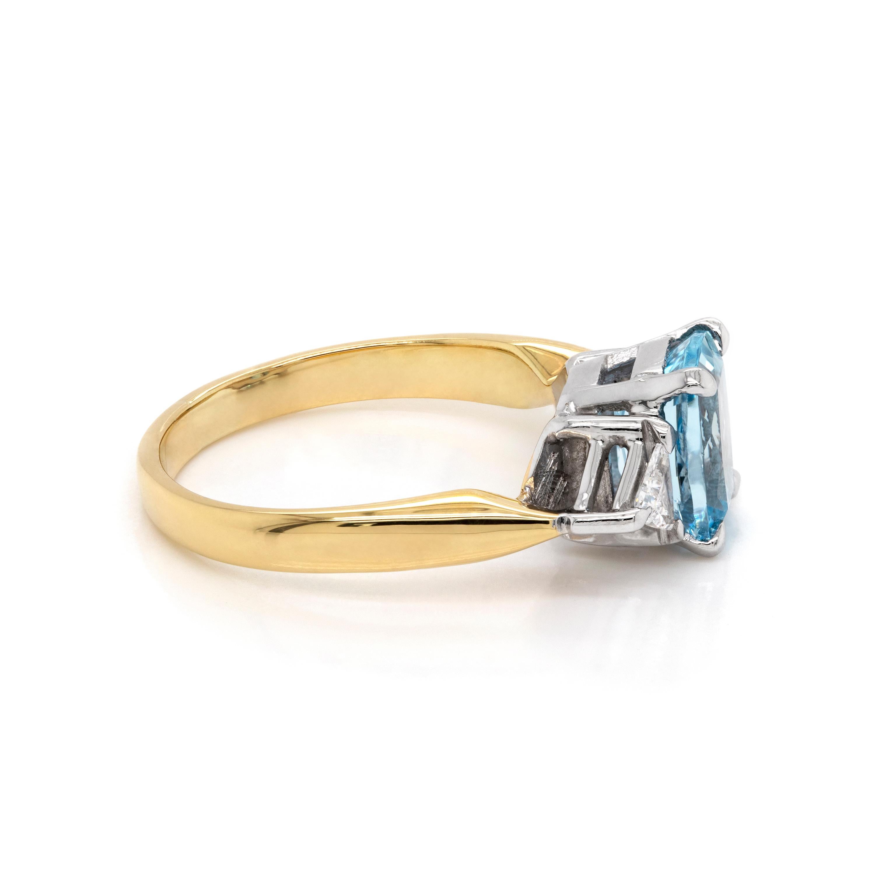 This beautiful ring features a 1.48 carat elongated cushion cut aquamarine mounted in a four claw, open back setting. The aquamarine is beautifully accompanied by a trillion cut diamond on either side mounted in a three claw, open back setting, all