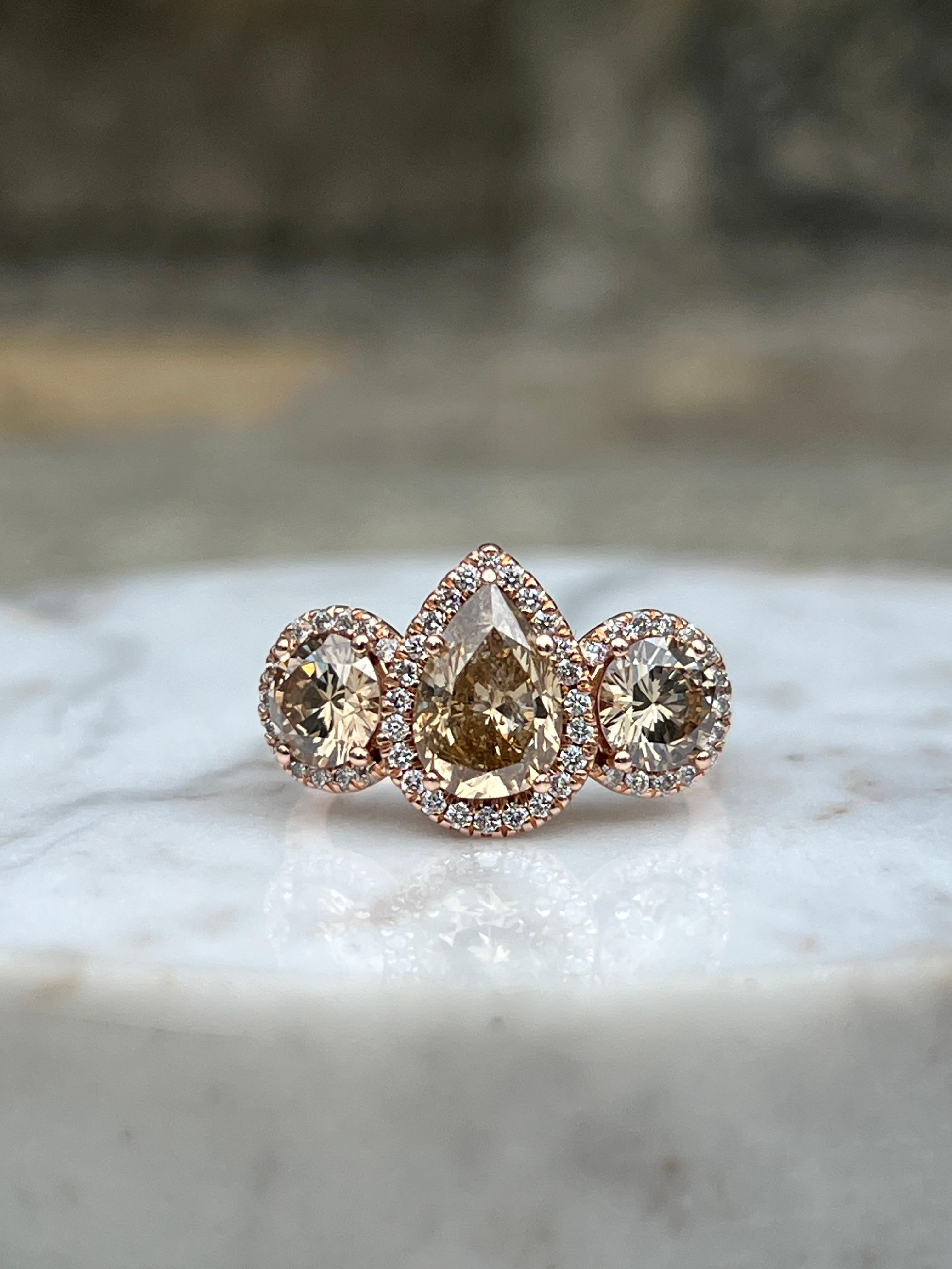 Cette bague de fiançailles contemporaine en or rose 14 carats au design personnalisé de Martin Flyer est une déclaration audacieuse et romantique, mettant en vedette un captivant diamant brun fantaisie en forme de poire de 1,48 carats aux tons