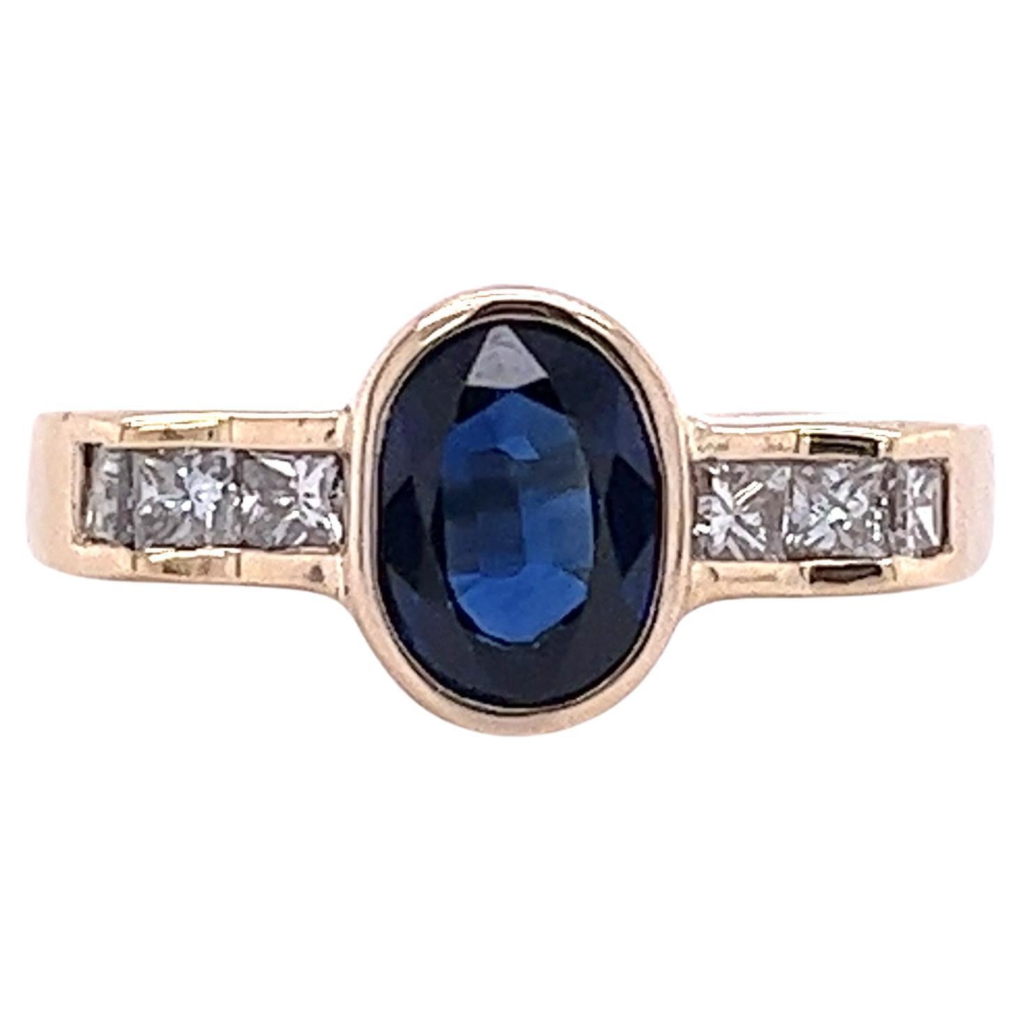 1.48 Carat Oval Cut Blue Sapphire with Princess Cut Diamonds in 18k Yellow Gold