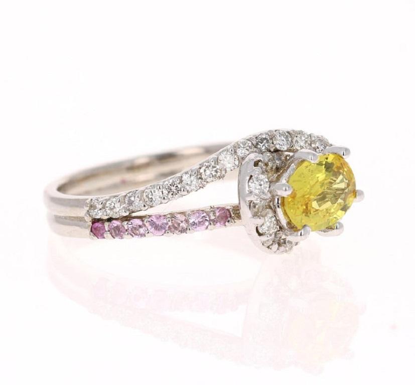 This ring has an oval cut Yellow Sapphire that weighs 0.87 carats and is surrounded by 14 Pink Sapphires that weigh 0.29 carats and 20 Round Cut Diamonds that weigh 0.32 Carats (Clarity: VS, Color: H) 
The total carat weight of the ring is 1.48
