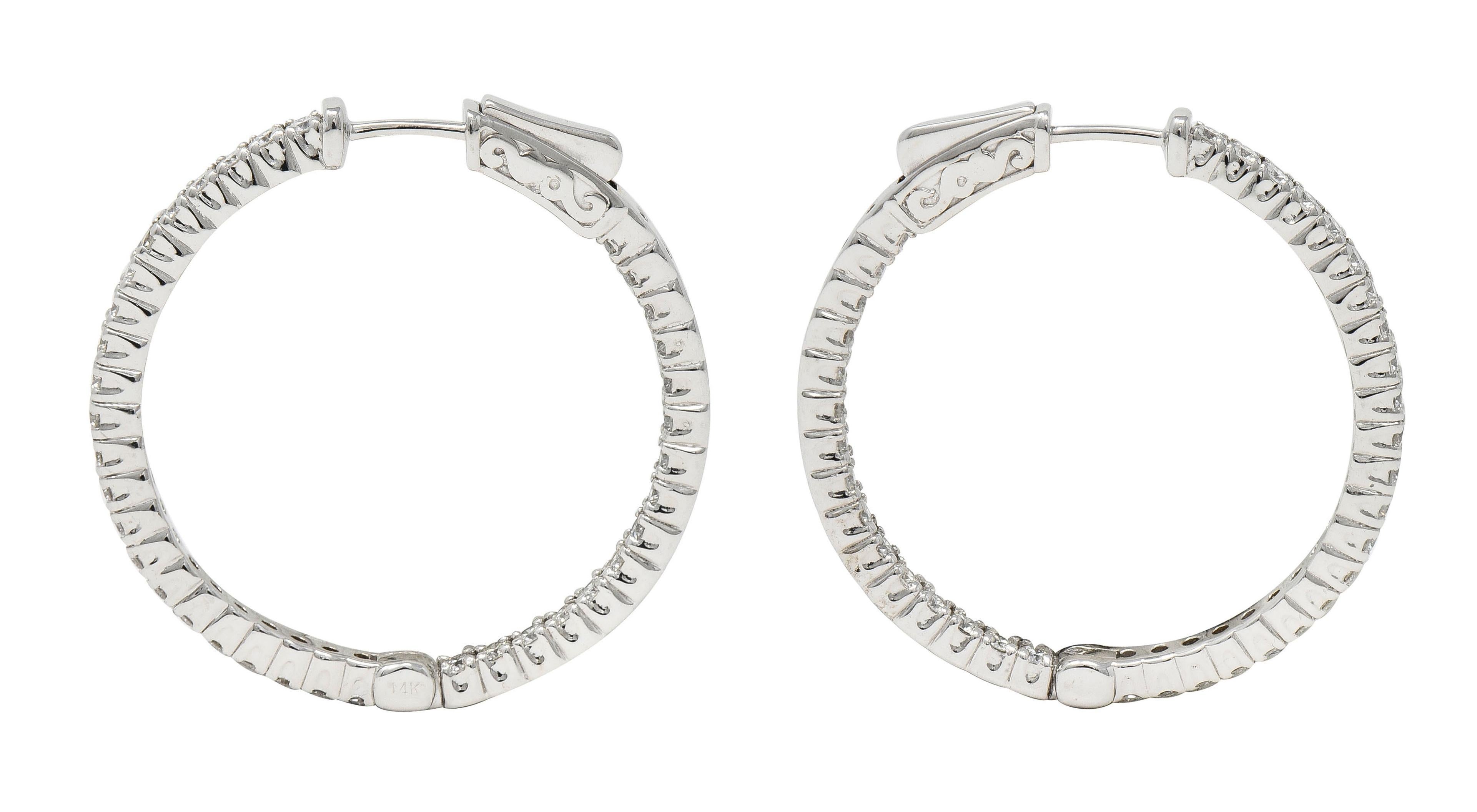 Designed as round inside-outside style hoop earrings
Prong set with round brilliant cut diamonds
Weighing 1.48 carats total 
G/H color with overall VS clarity
Opens on a hinge via press release backs
Complete with posts 
Inscribed with carat