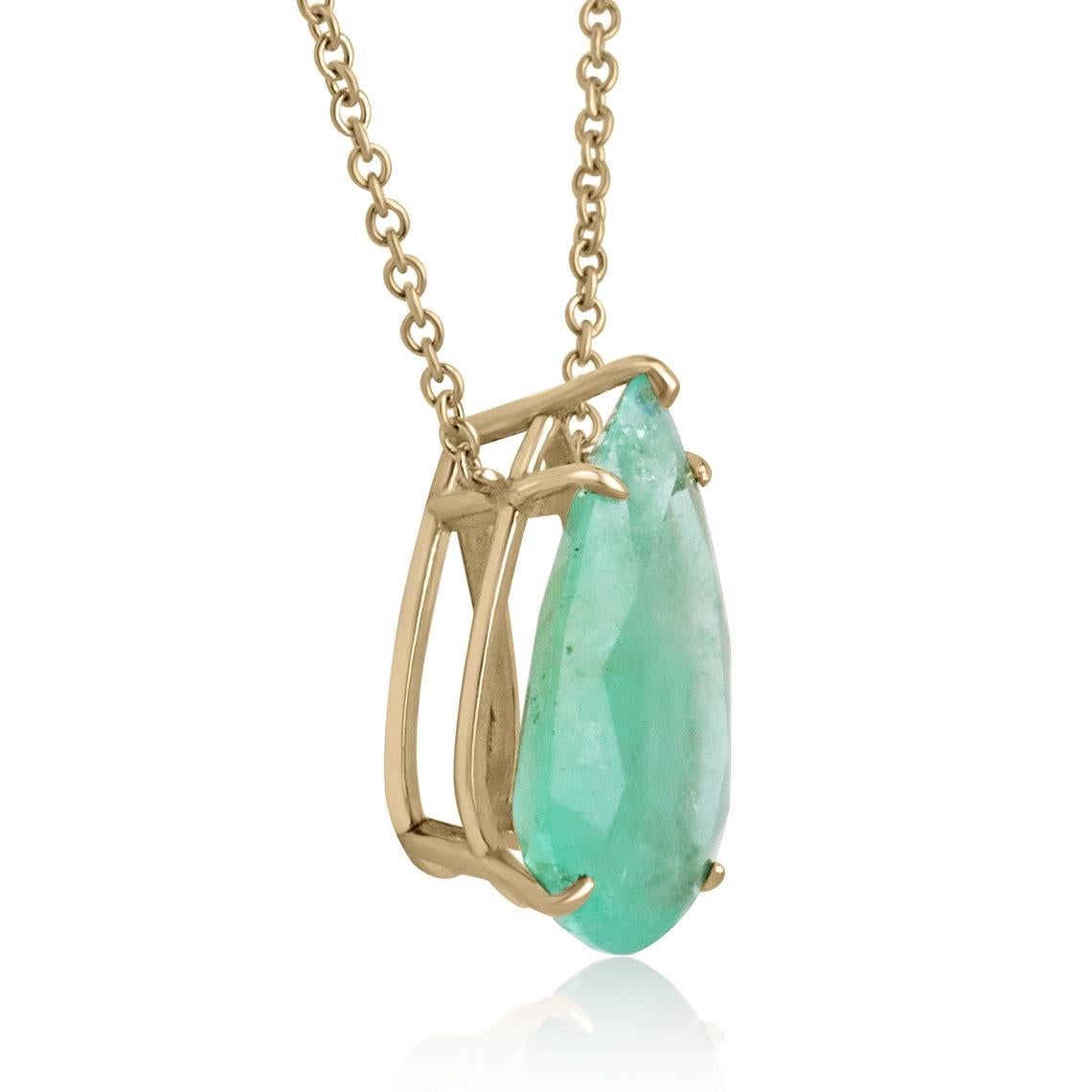 Displayed is a classic Colombian emerald solitaire necklace set in 14K yellow gold. This gorgeous solitaire piece carries a massive, natural Colombian emerald in a five-prong setting. Fully faceted, this big, rare gemstone showcases great shine. The