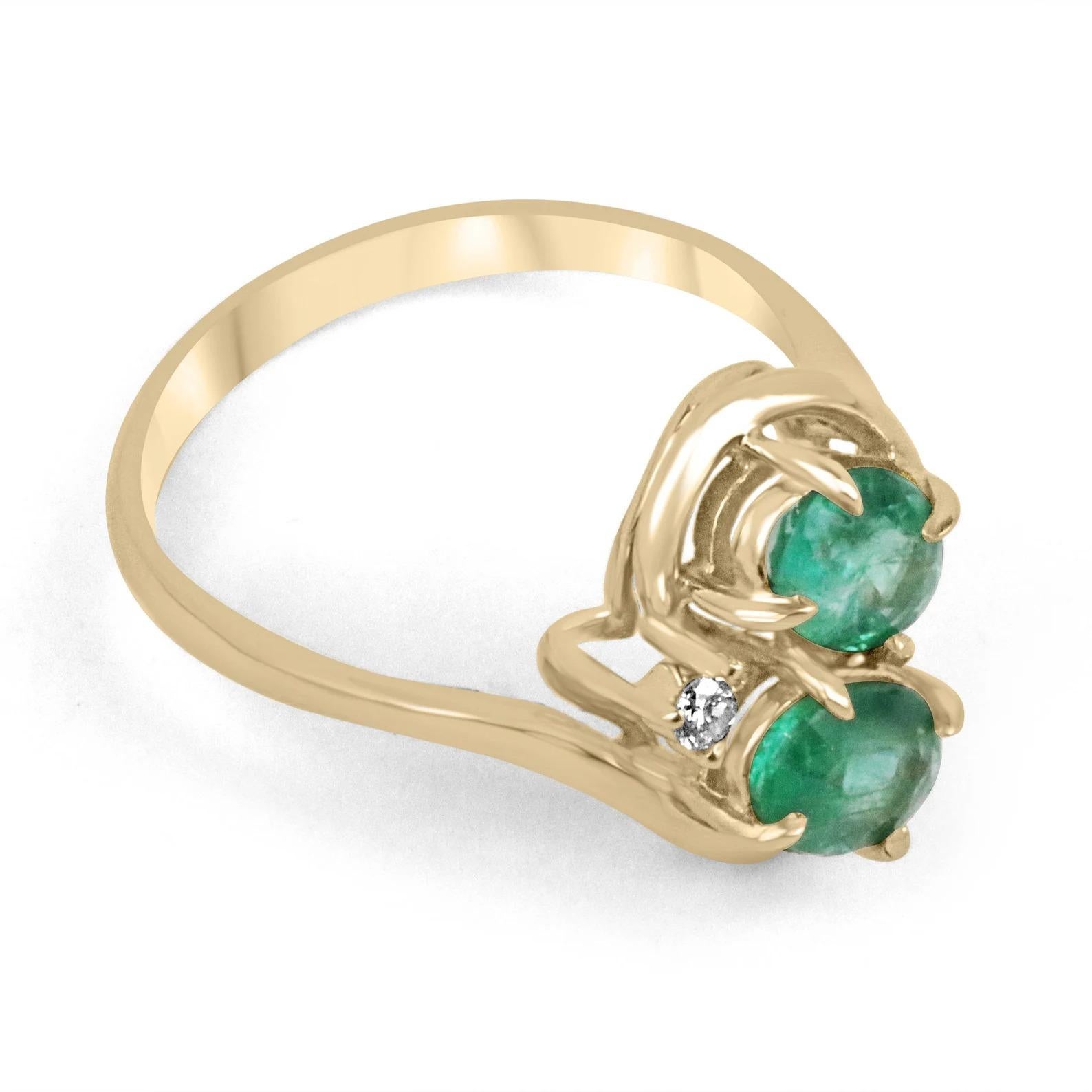 A double oval natural emerald & diamond ring in solid 14K yellow gold. Two, medium-green natural emeralds are used in this unique dual setting. The gemstones have the same beautiful color and similar eye clarity. No two emeralds are alike and this
