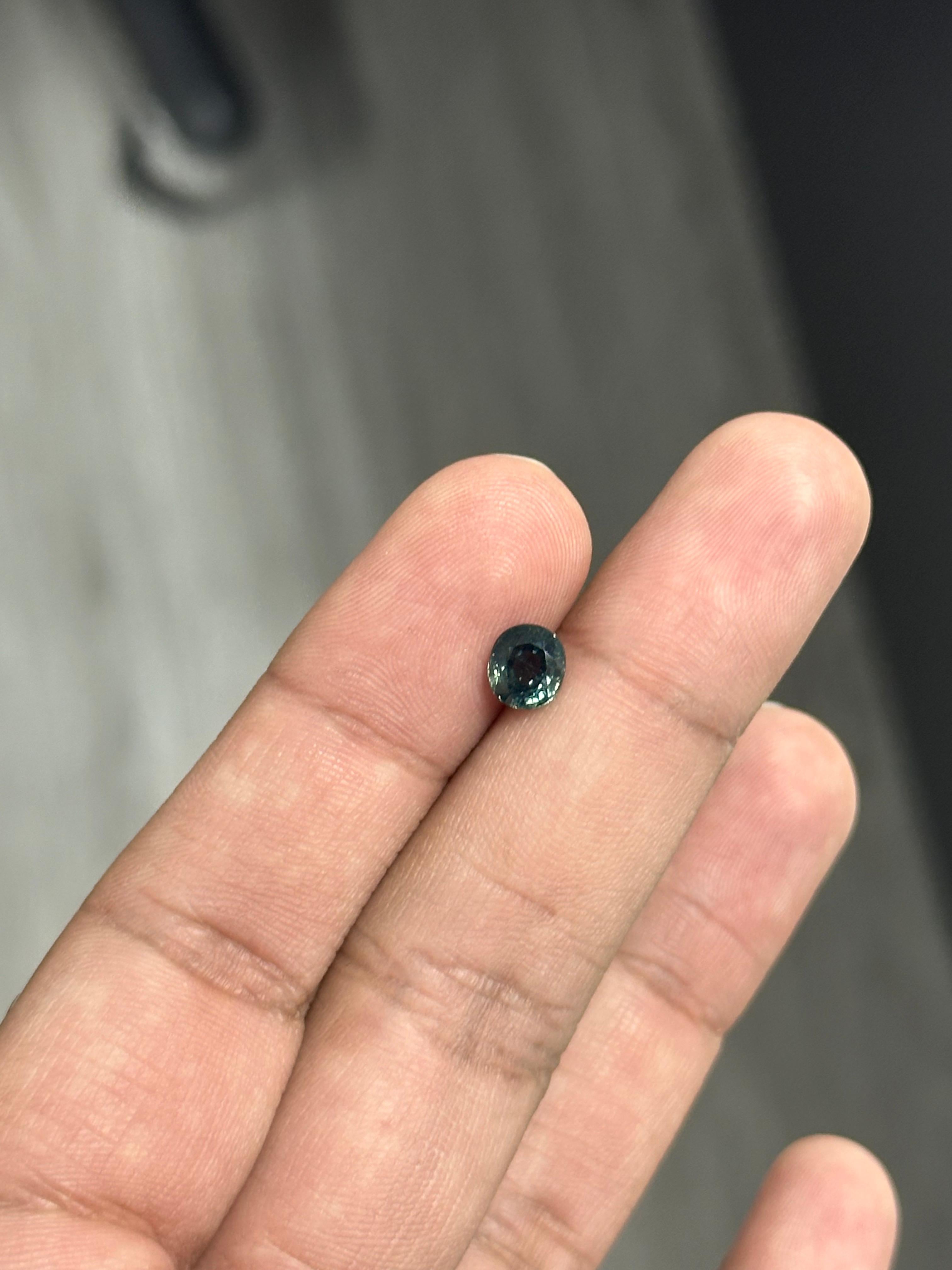 A 1.49 Carat Sapphire, resplendent in a teal blue hue. It hails from the enchanting gem mines of Sri Lanka. This exquisite gem has not undergone any form of treatment, maintaining its 100% natural origin. The sapphire is cut to perfection in an oval
