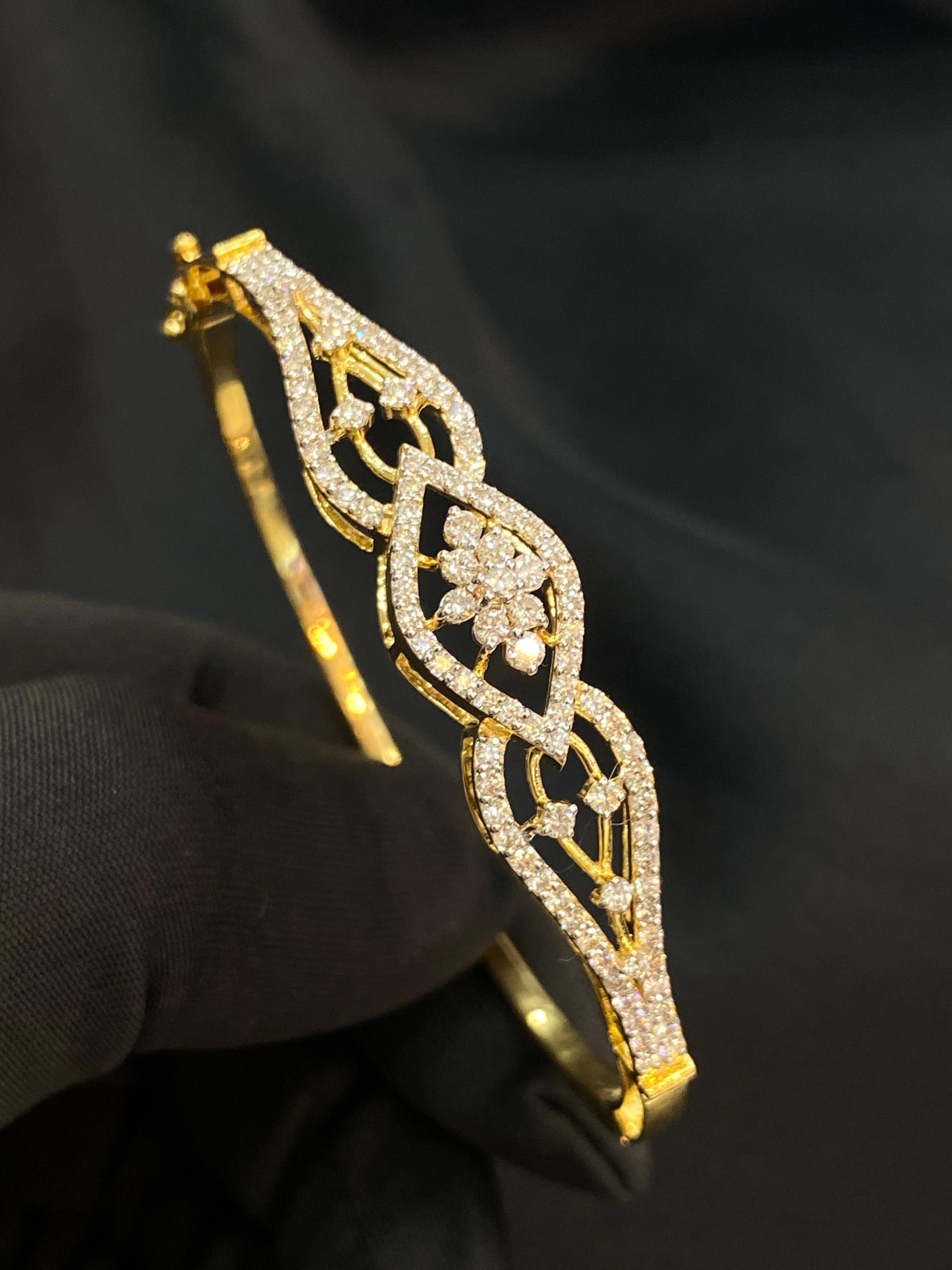 Un bracelet a quelque chose de vraiment enchanteur - il a le pouvoir d'évoquer un sourire à un million de dollars. Ornez votre poignet de cet exquis bracelet à charnière, orné de 1,49 carats de diamants ronds de taille brillant F/VS1 en or jaune 14