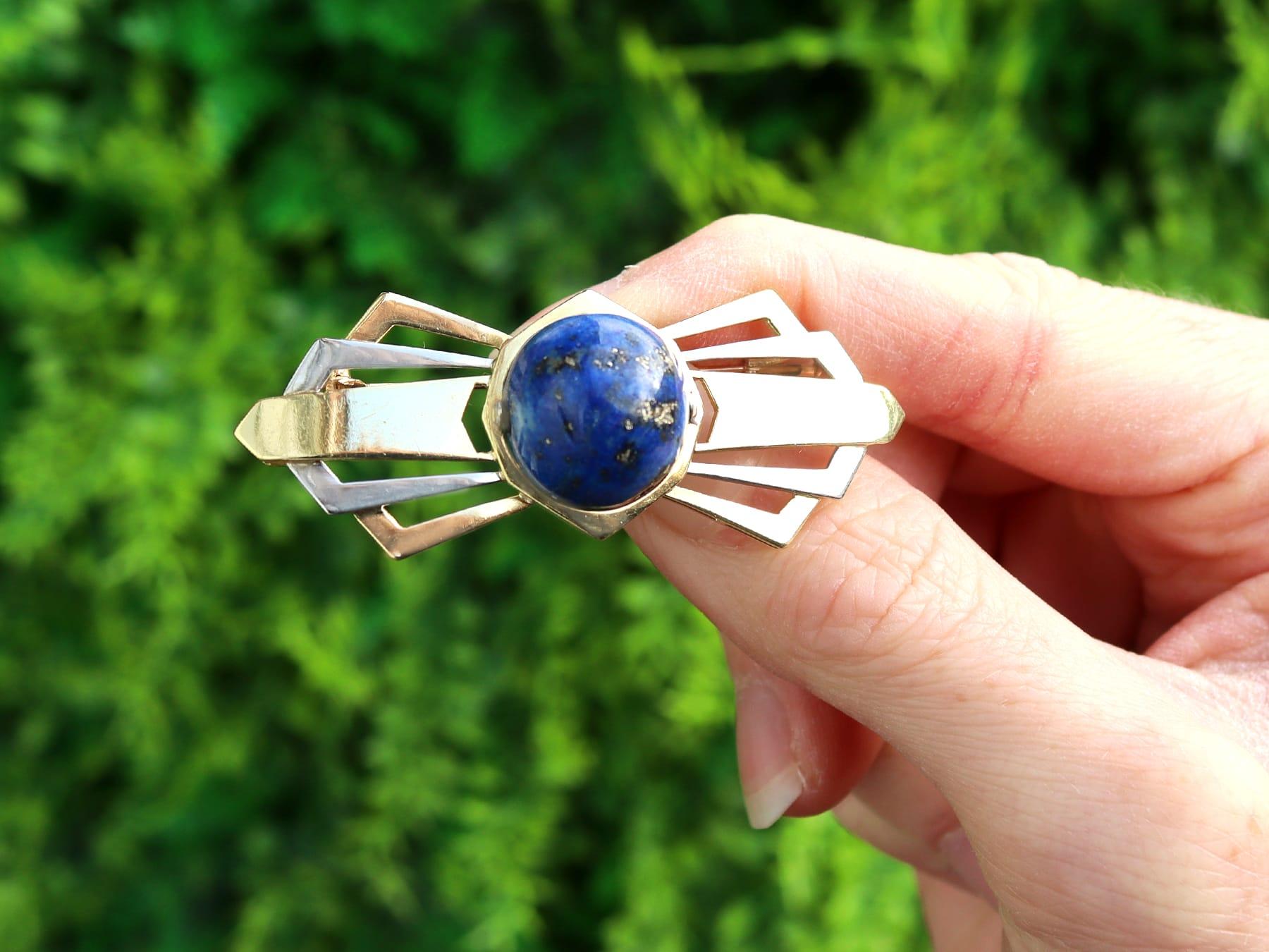 An impressive antique 1930s Art Deco 14.95 carat lapis lazuli, 18 karat yellow and white gold bow brooch; part of our diverse antique jewelry and estate jewelry collections.

This fine and impressive antique brooch has been crafted in 18k yellow and