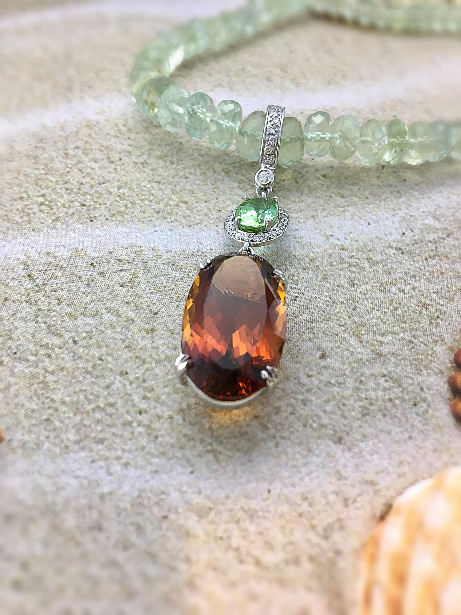 This diamond set enhancer showcases a stunning oval Madeira citrine with a weight of 14.66 carats and a stunning oval mint tourmaline (weight 1.79 Carat), surrounded by small grain set round diamonds. This is a detachable pendant with a beautiful