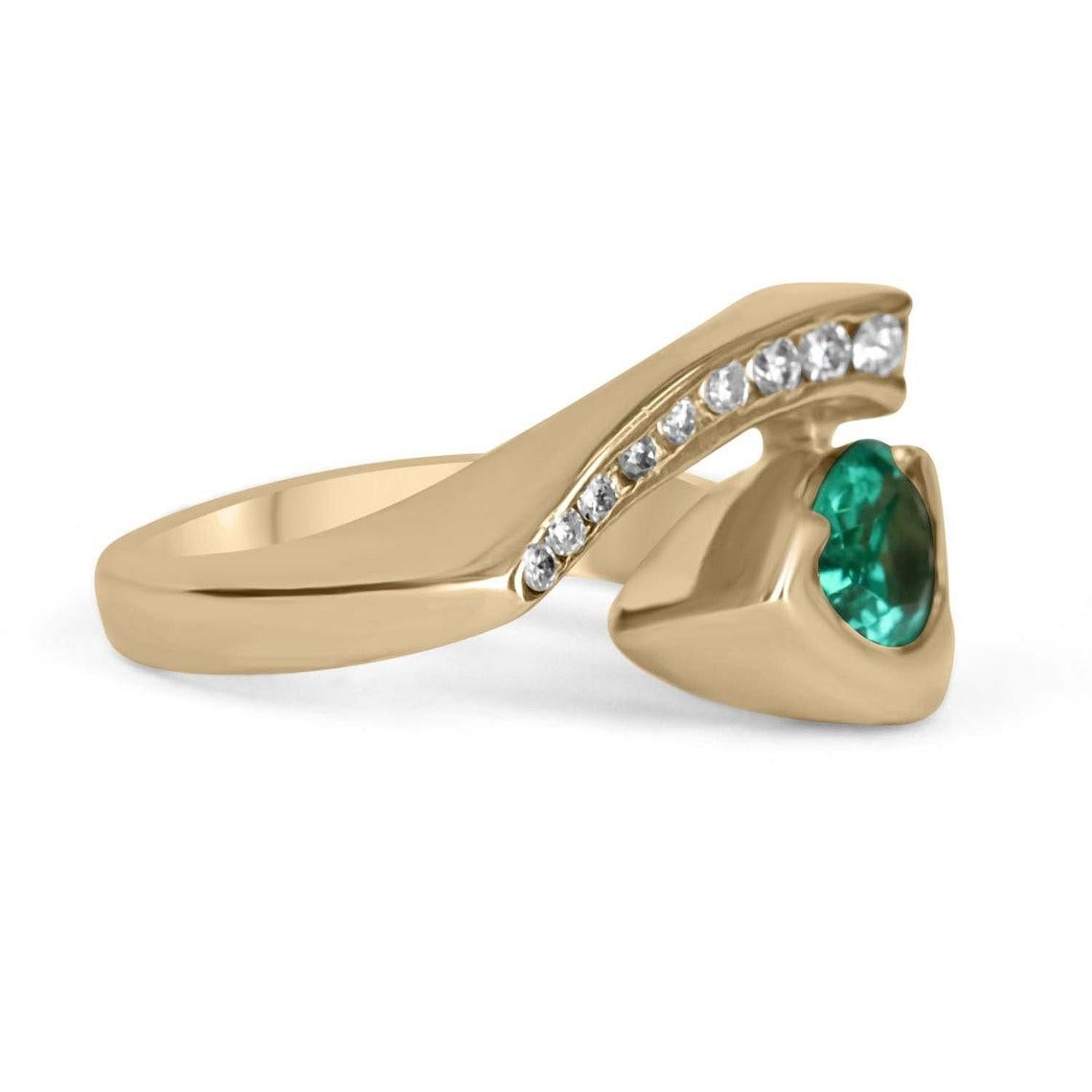 This is a stunning 14K yellow gold, Zambian emerald and diamond statement ring or right-hand ring. Absolutely stylish and sleek, ideal as a stand-alone piece or worn with other statement pieces. A teardrop-cut Colombian emerald is set in our