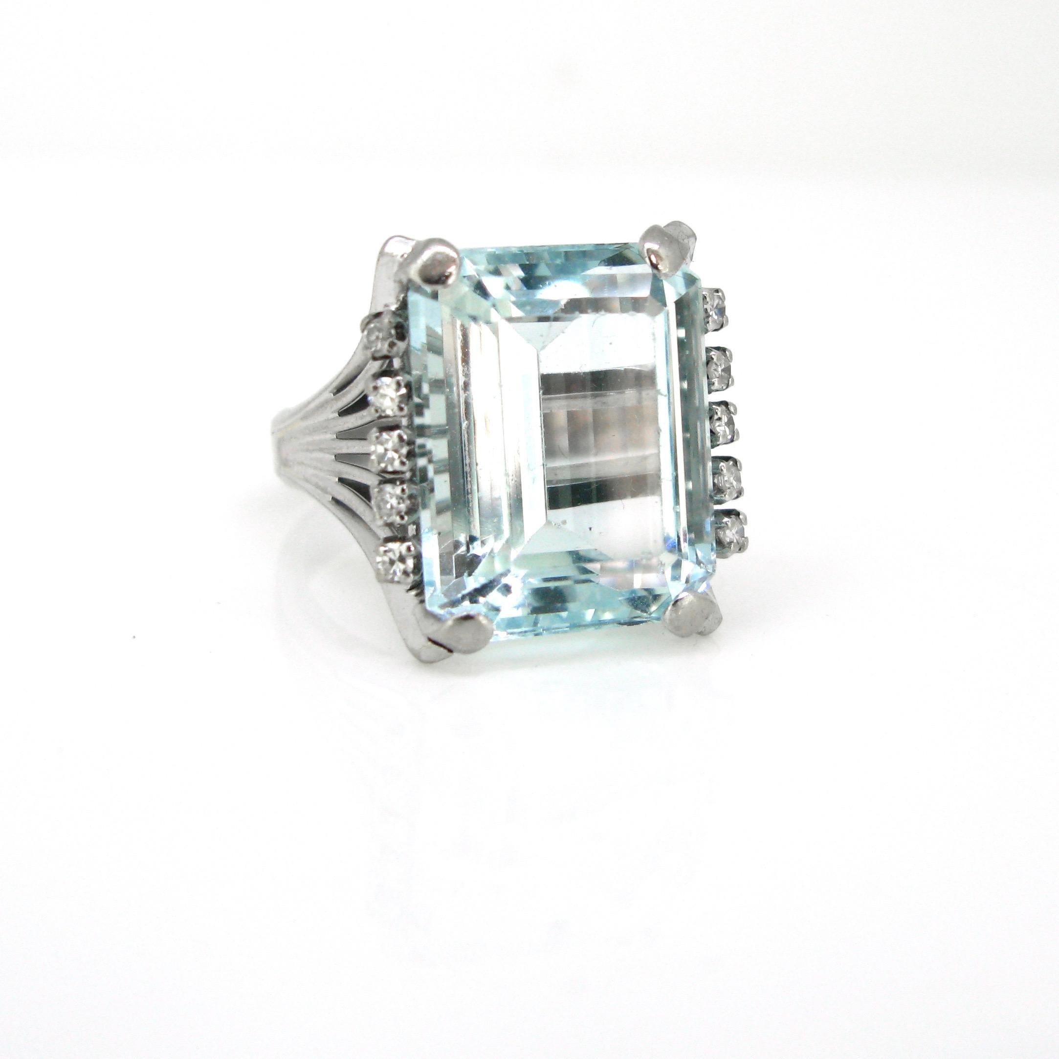 This Cocktail ring is made in 18kt white gold. It is set with an eye clean aquamarine weighing around 14ct. It is shouldered with 5 single cut diamonds on each side The ring has been controlled with the French hallmark: the owl. Aquamarine