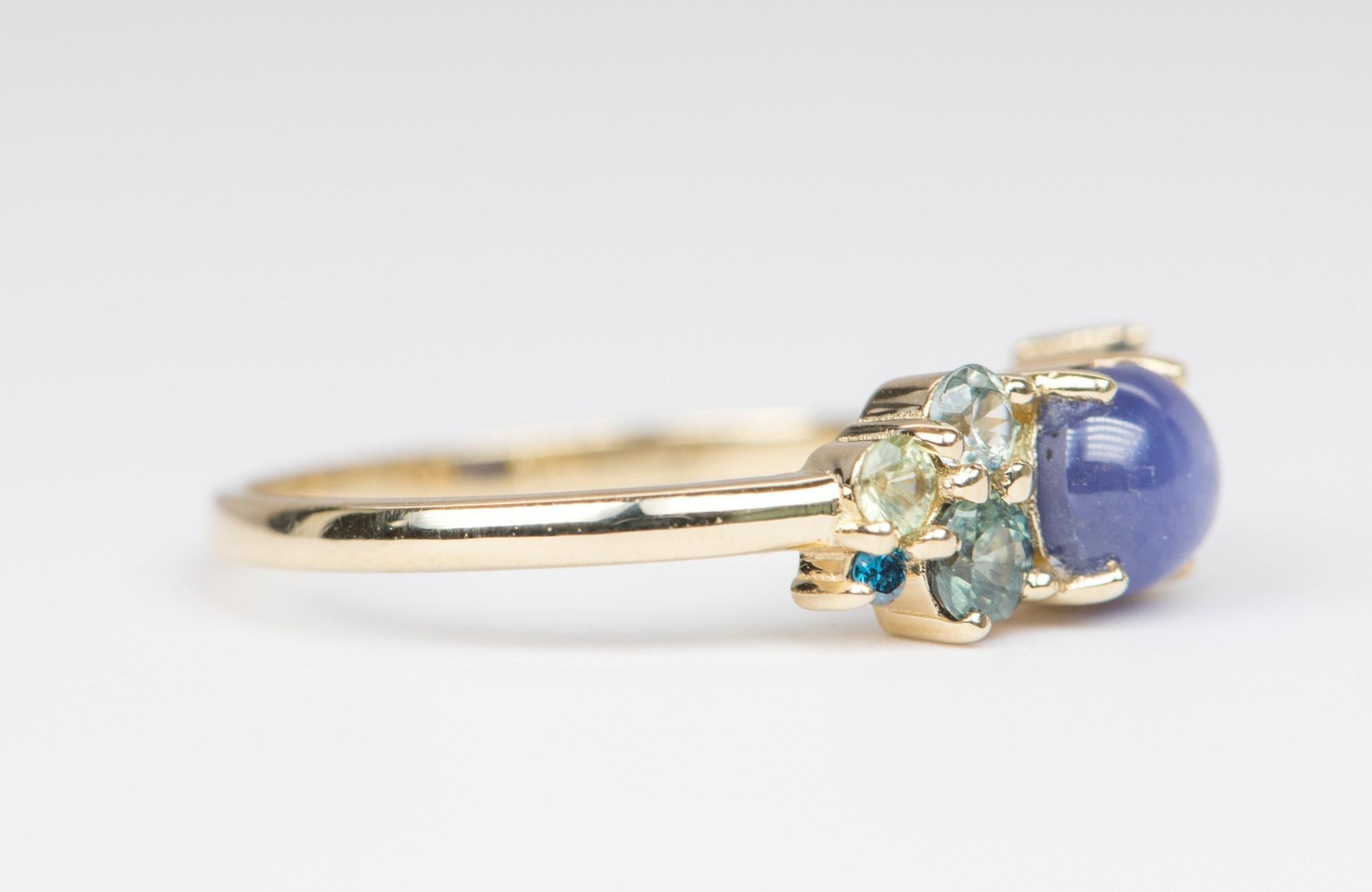 ♥  A solid 14k yellow gold ring set with a oval shaped natural un-heated cabochon star sapphire in the center, flanked by a cluster of beautiful gemstones to complement the unique color in the center stone.
♥  The overall setting measures 15.5mm in