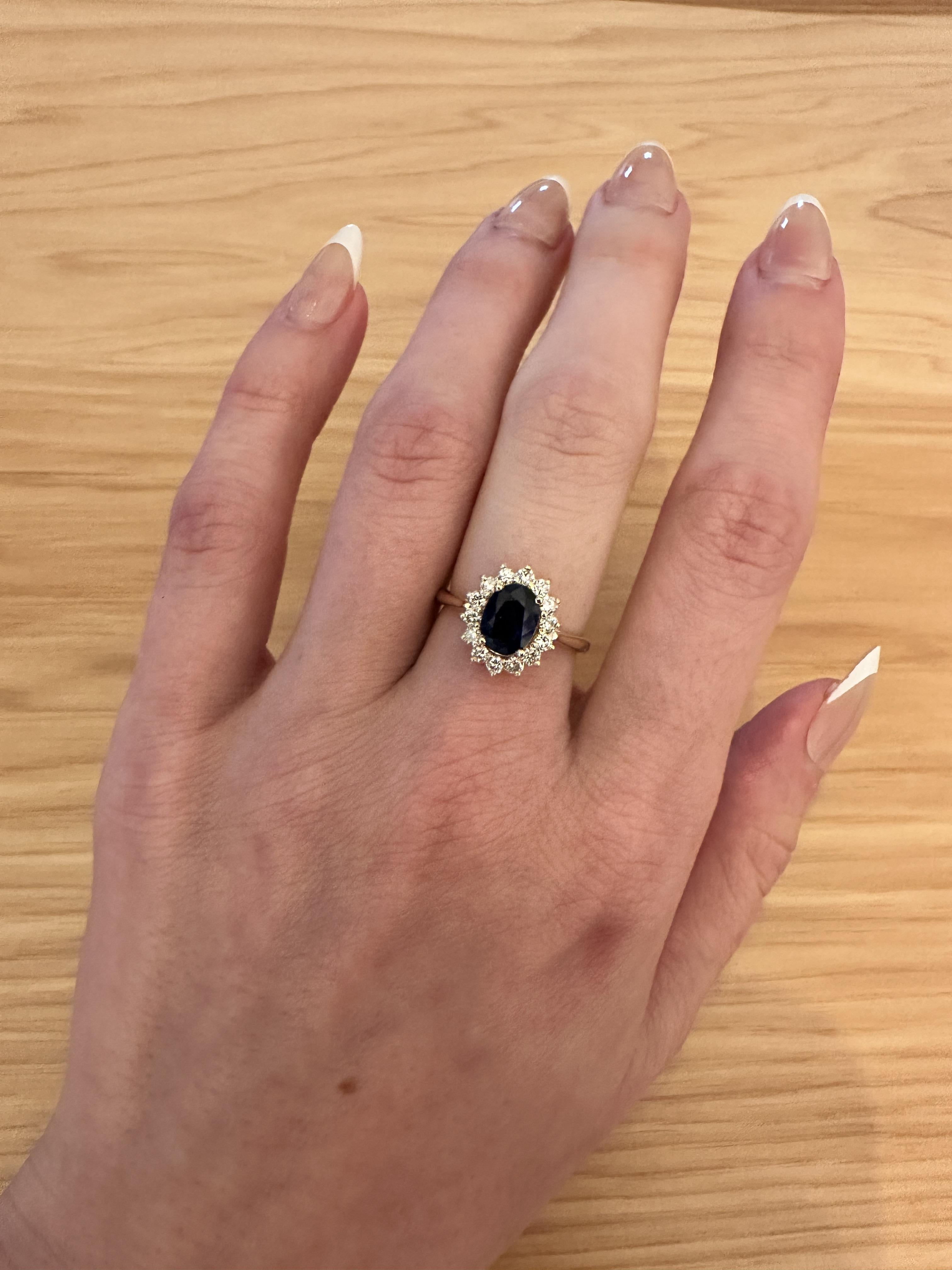 Introducing our Statement Princess Diana Inspired Blue Sapphire Ring in 14K Yellow Gold. Featuring a 1.4ct Sapphire and a natural diamond halo, this ring adds a touch of elegance to any outfit. Make a statement with this unique piece.

**We offer