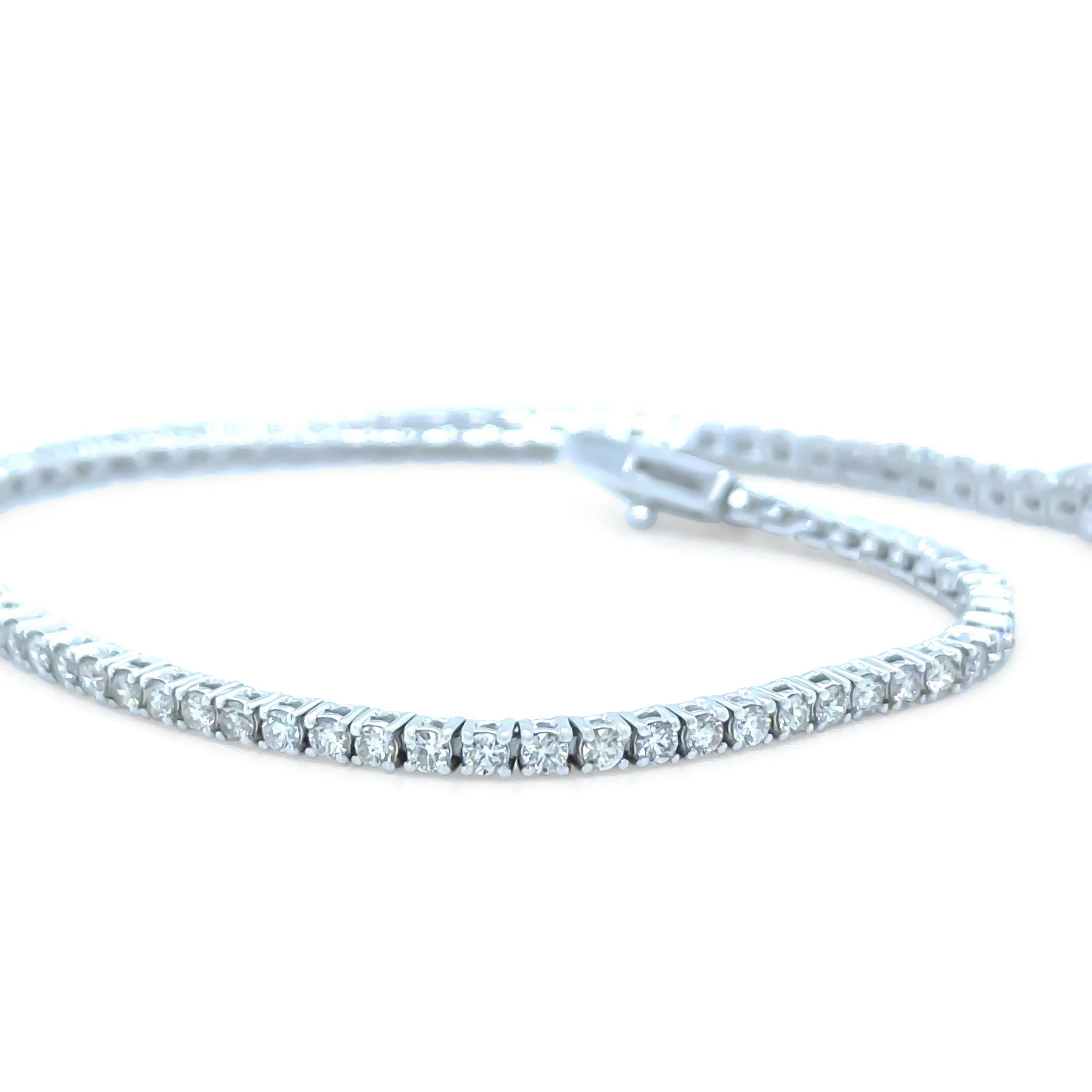This elegant 14ct white gold diamond tennis bracelet features eighty-one round brilliant-cut diamonds, each approximately 1.8mm in diameter, securely set in classic four-claw mounts. The diamonds have a total estimated weight of 2.00ct, graded J-K