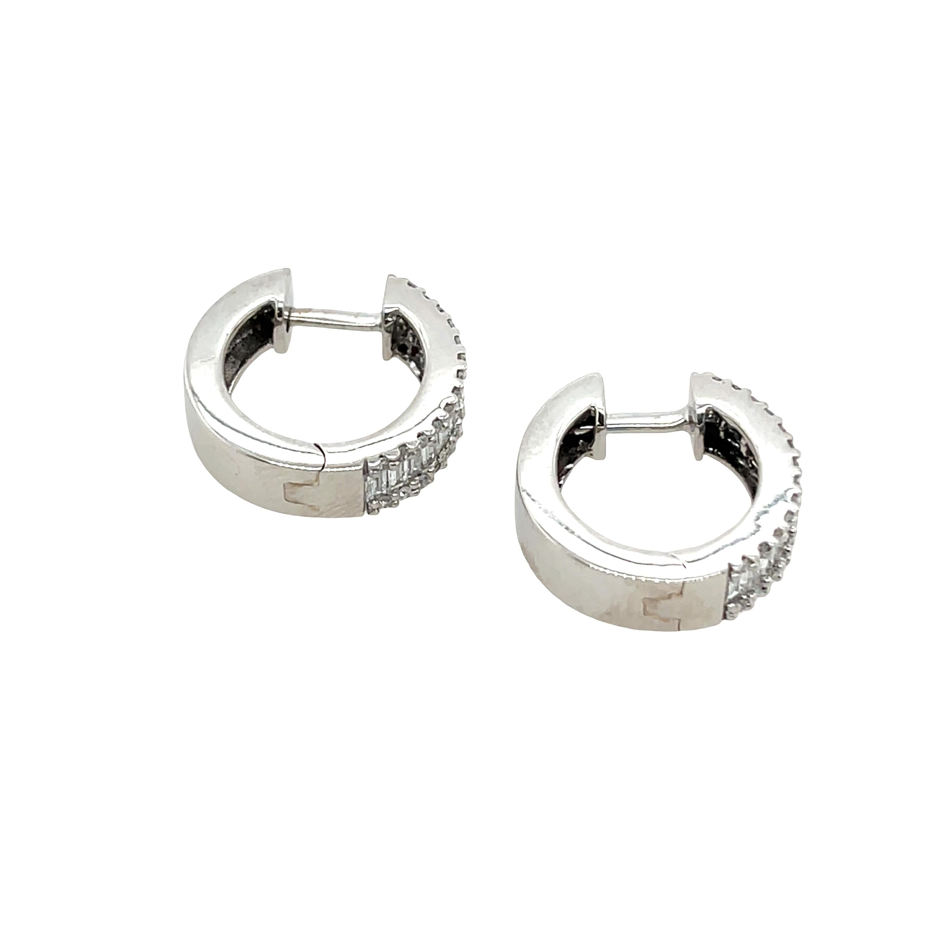 Questo paio di orecchini a cerchio con diamanti è stato progettato per essere l'orecchino perfetto per tutti i giorni. Presenta un totale di 0,95 carati di diamanti rotondi e baguette montati su un cerchio in oro bianco 14 carati. 

Peso totale: