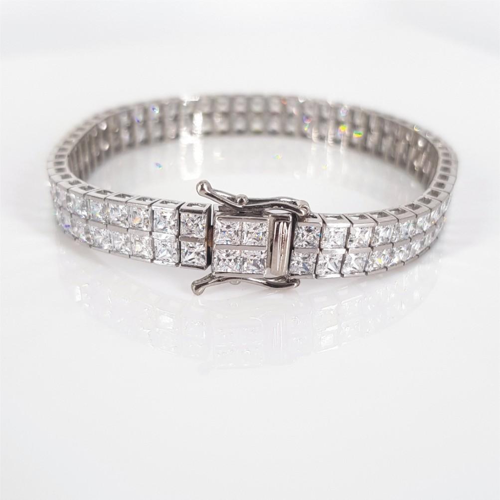 A beautiful Tennis bracelet set in 14 carat White gold, studded with 110 Princess cut Cubic Zirconia’s. All the stones are prong set. The bracelet weighs 20 grams, is 17.5cm in length, 7mm thick and has a Fold-over and Push Clasp.