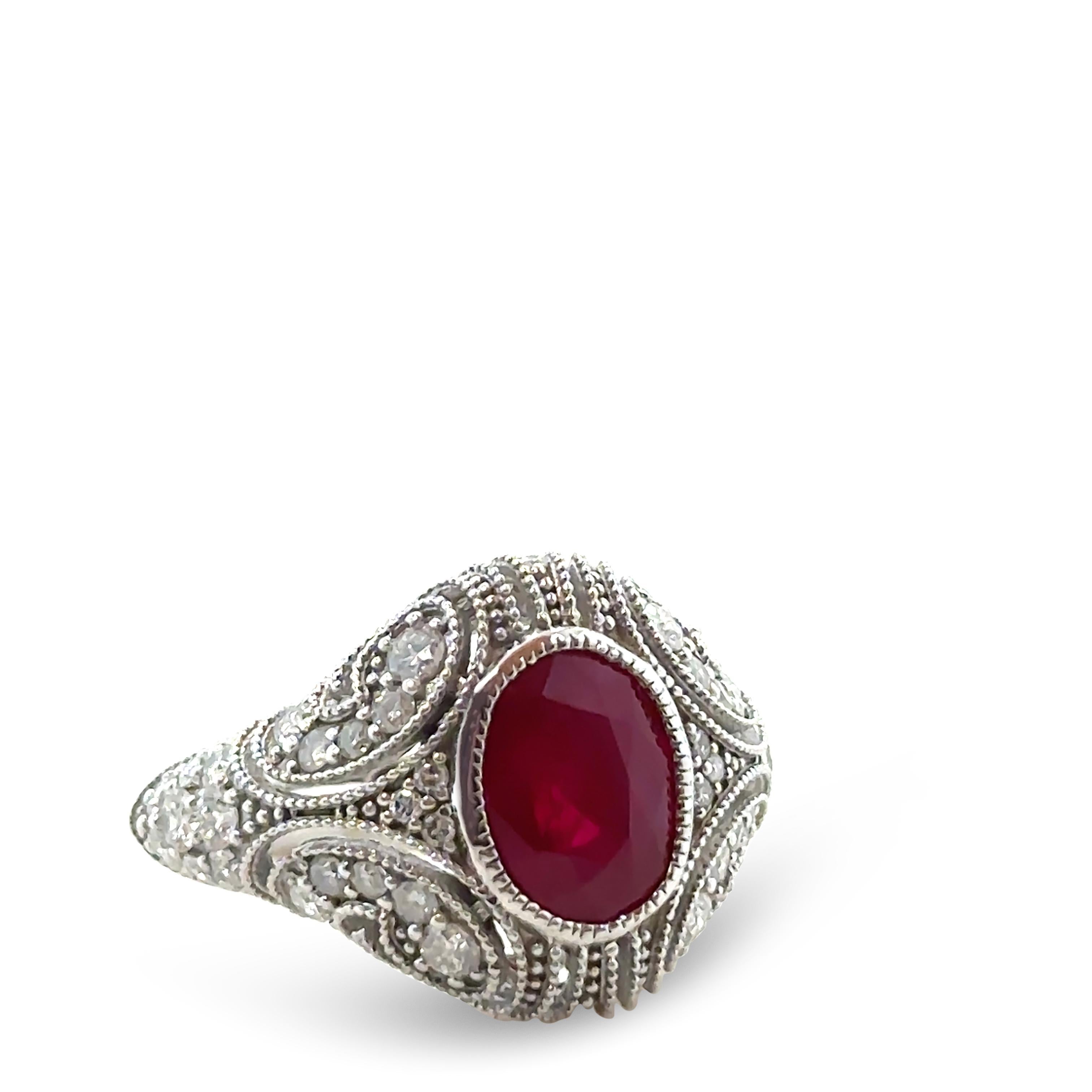 This exquisite 14ct white gold art deco-style ring is a stunning display of craftsmanship and elegance, featuring a claw-set 2.75ct natural oval-cut ruby. The ruby boasts a rich medium deep pinkish-red hue, semi-transparency, and a few natural