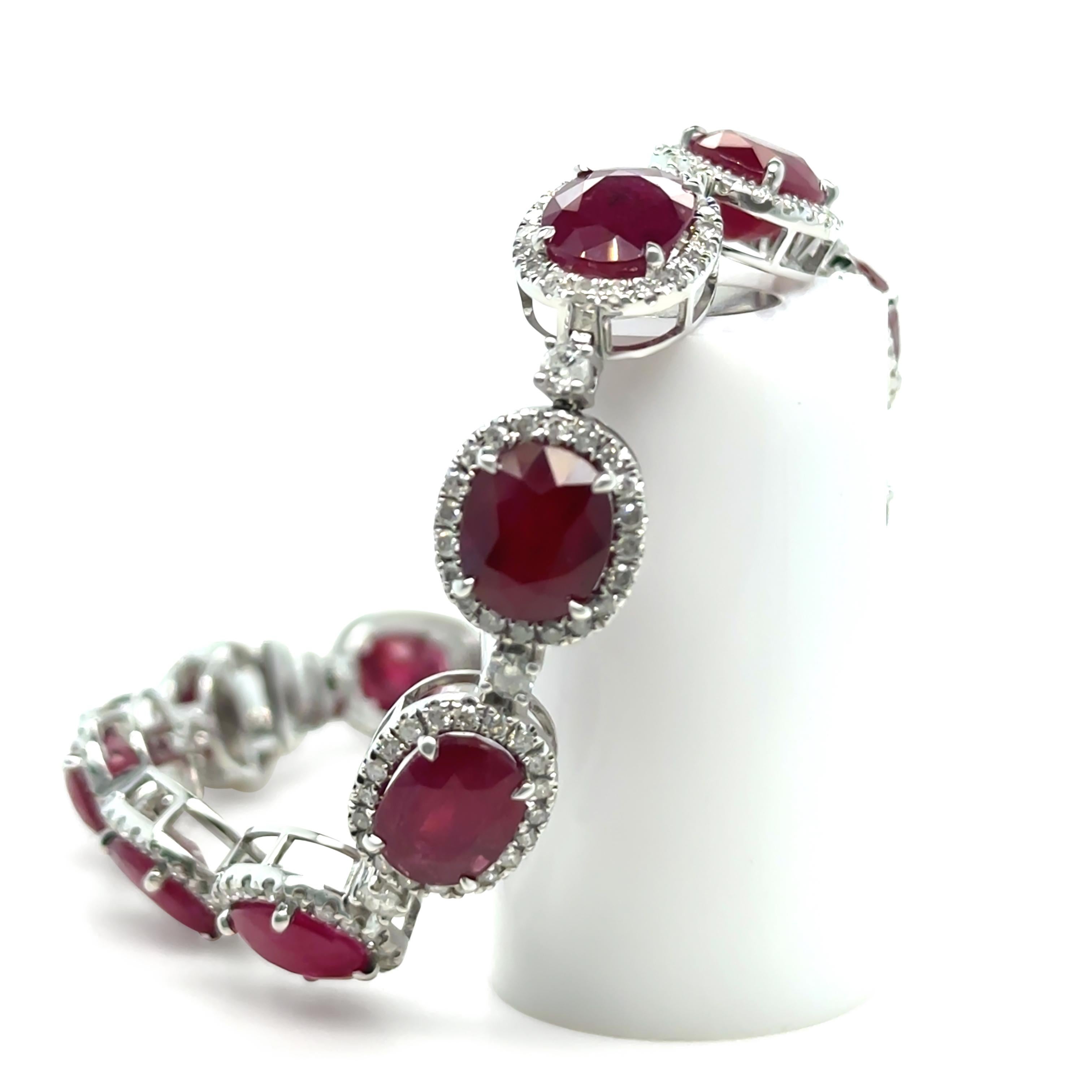 This exquisite ruby and diamond bracelet showcases timeless beauty, crafted in 14ct white gold with a total weight of 17.5 grams. The bracelet features 13 oval, red, mixed-cut rubies, each approximately 2.05 carats, with a combined total ruby weight